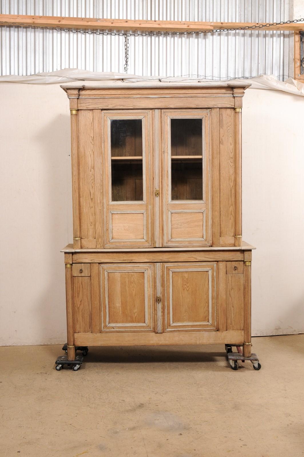 A French Neoclassical tall bleached-oak display and storage cabinet from the mid 19th century. This handsome cabinet from France, often referred to as a buffet à deux-corps (which is the name for a French buffet consisting of an upper and lower