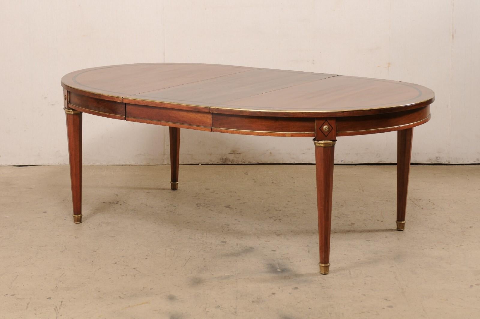 20ième siècle Table ovale de style néoclassique français avec garniture et accents en laiton (1 rallonge en forme de feuille) en vente