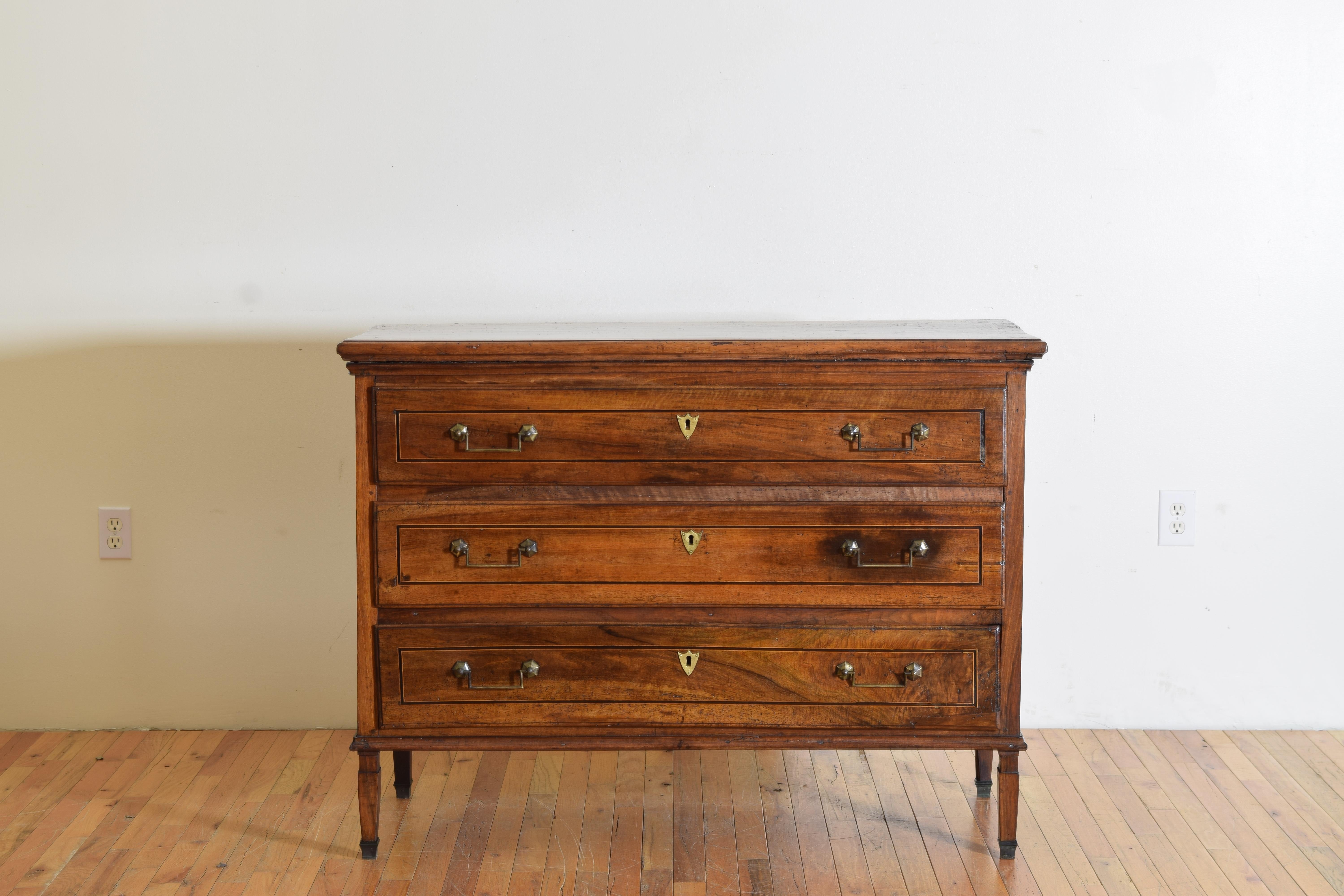 Having a rectangular top with molded edge atop a conforming case housing 3 drawers each with ebonized banding and brass handles and escutcheons, the sides with raised rectangular paneling, raised on interesting slender and deeper than wider feet