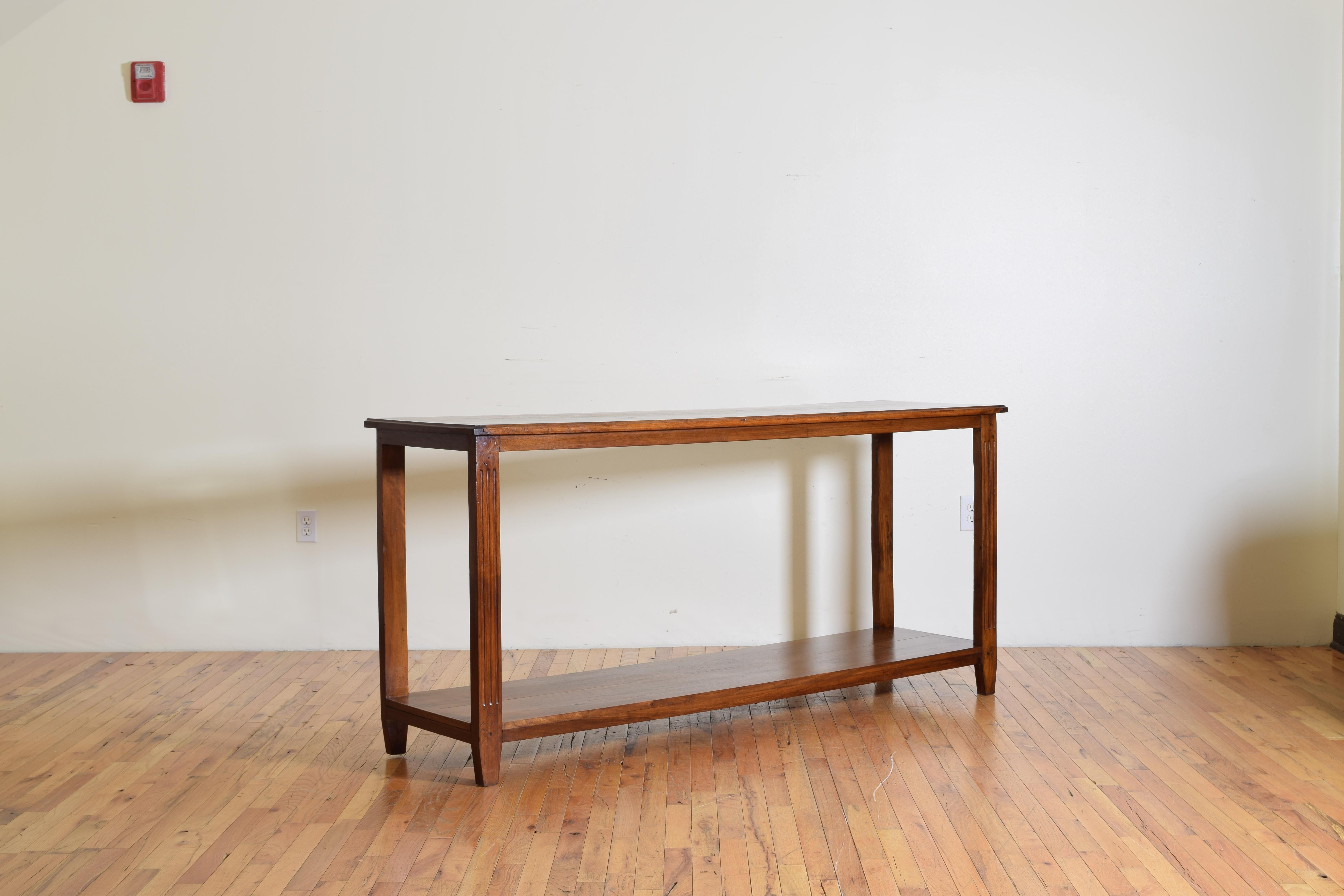 The rectangular top having a molded edge atop a conforming frame raised on slightly tapering fluted front legs and rectangular back legs, with a lower solid walnut shelf.