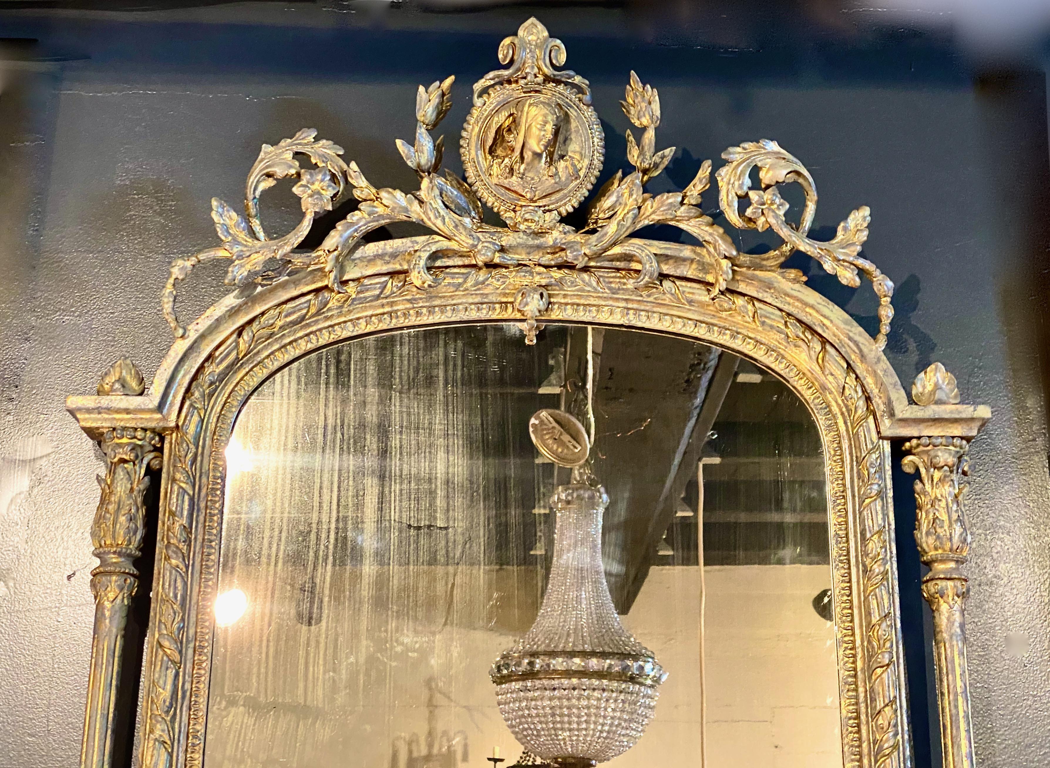 This is an uncommon 19th century neoclassical French mirror. The mirror retains its original mirror plate that has acquired a subtle patina. The gilt wood frame is in overall good conditions with normal natural patina and minor superficial