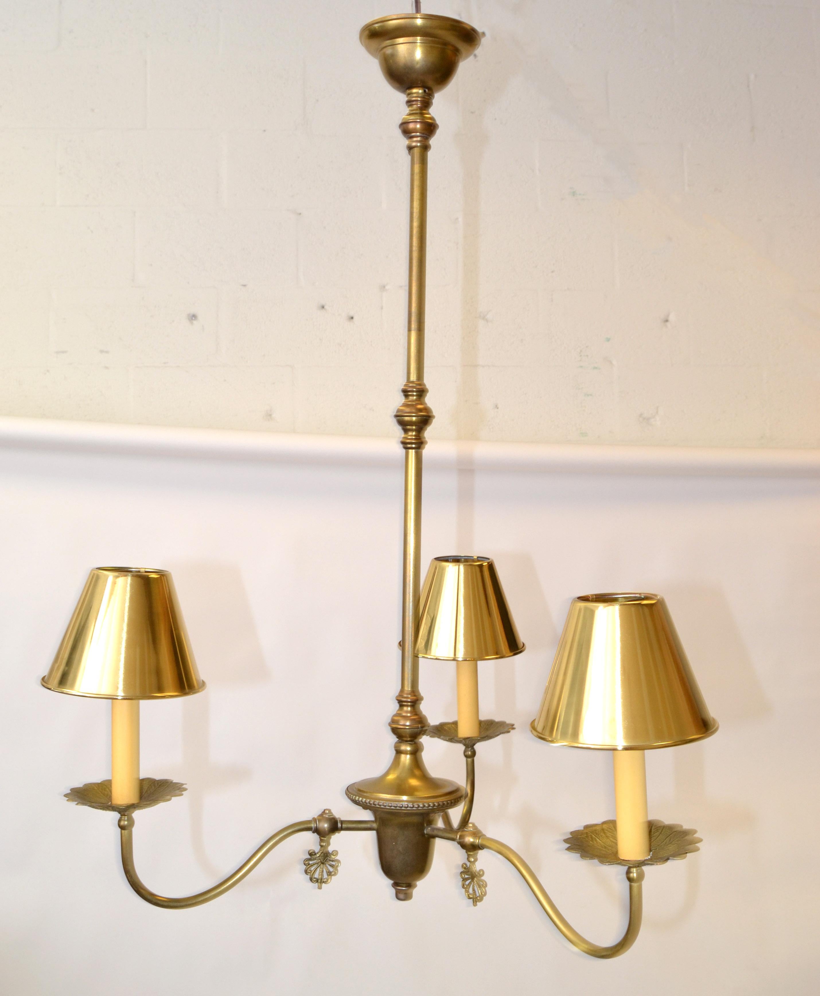 French neoclassical 3 light pendant lamp chandelier in brass with brass clip-on shades.
Handcrafted Ornate brass saucers and decoration made in the 1950s in France.
Wired for the US and takes 3 candelabras light bulbs, 25 watts / 120 V.
New brass