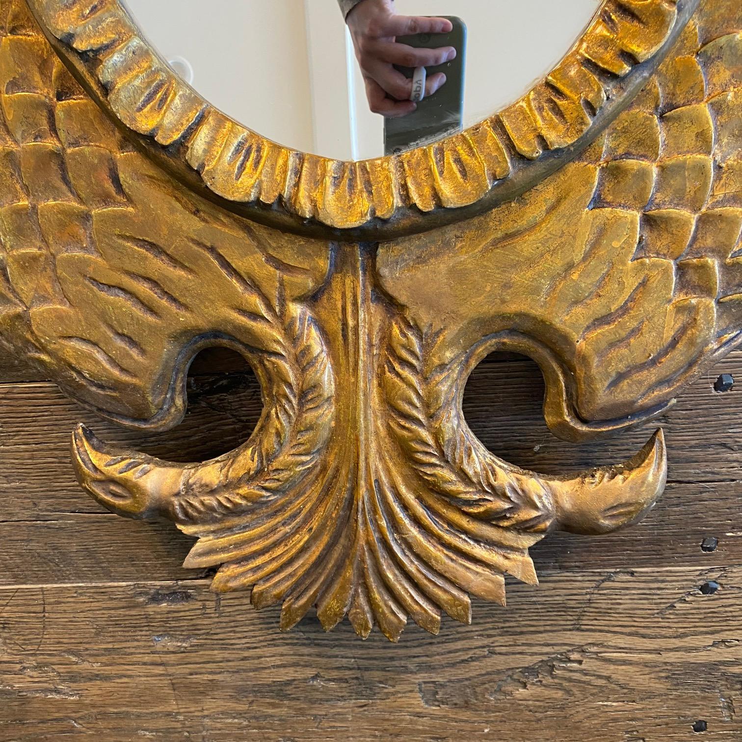 Squisita cornice per specchio francese in legno dorato intagliato a forma di aquila bicefala bicipite coronata. Cornice altamente decorativa con aquile a due teste, ali simmetriche che racchiudono lo specchio circolare centrale. Questo specchio in