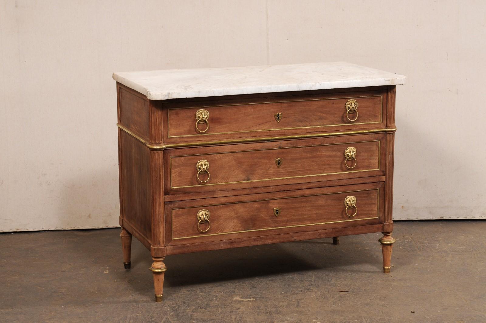 Una commode neoclassica francese, con piano in marmo originale e accenti in ottone, risalente al XIX secolo. Questo antico cassettone francese presenta un piano in marmo di forma rettangolare, con angoli pronunciati e arrotondati nella parte
