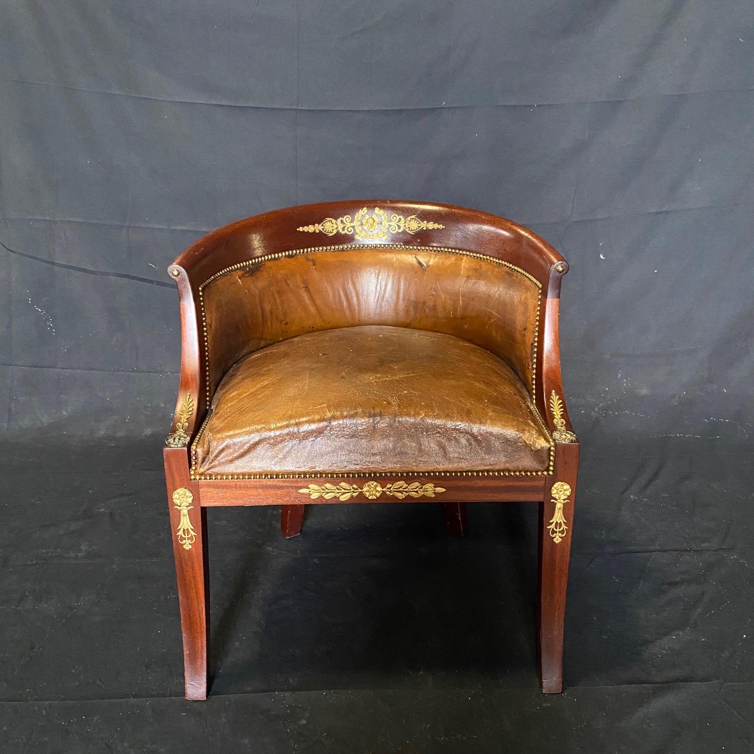 Beautiful aged French leather and walnut neoclassical desk or boudoir dressing table chair, in original leather with lovely brass tacking and stunning bronze jabots, with an acanthus leaf framed warrior head on the backrest crest.  arm height 26
