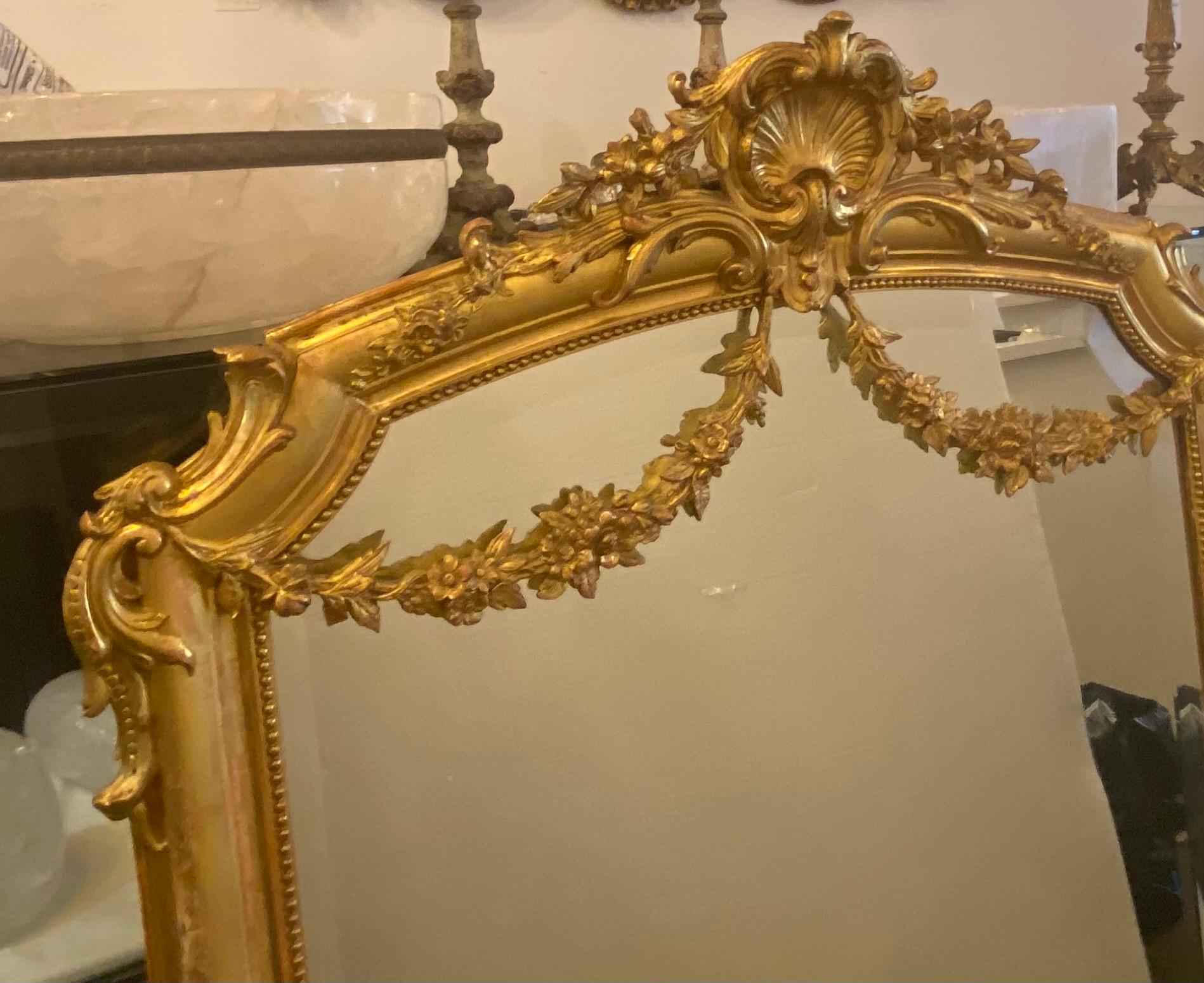 Fine antique neoclassical giltwood mirror. Elaborate scrolled and foliate decoration in rich gold leaf over wood. Good overall condition with minor wear. Some restoration to upper finial.