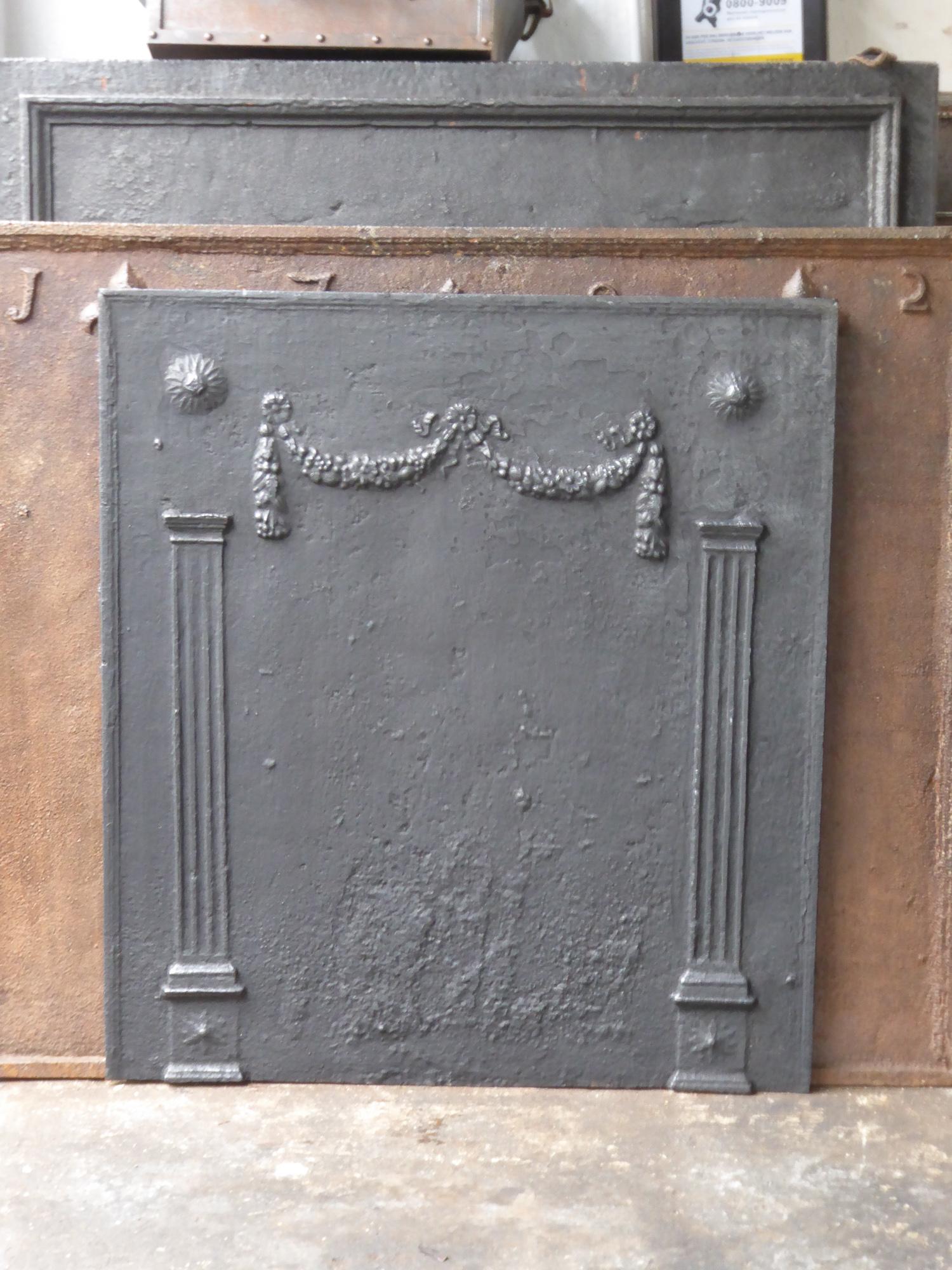 19th century French neoclassical fireback with two pillars of freedom. The pillars symbolize the value liberty, one of the three values of the French revolution. The fireback is made of cast iron and has a black