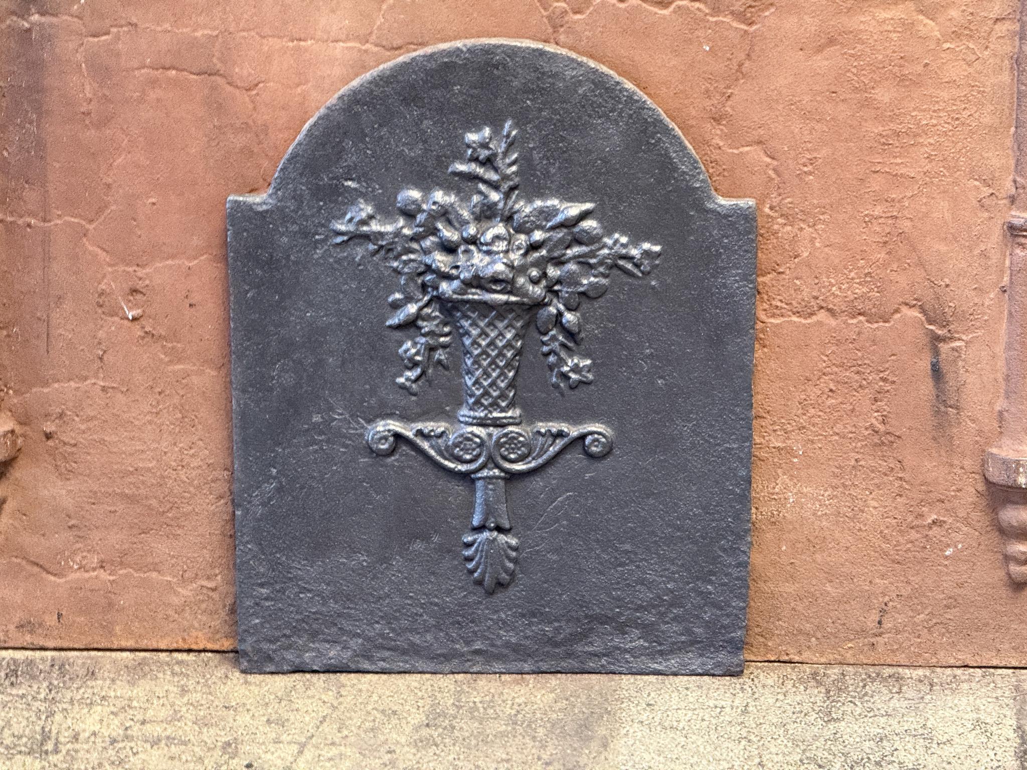 18th - 19th century French Neoclassical Period fireback with a flower basket.

The fireback is made of cast iron and has a black/ pewter color. 