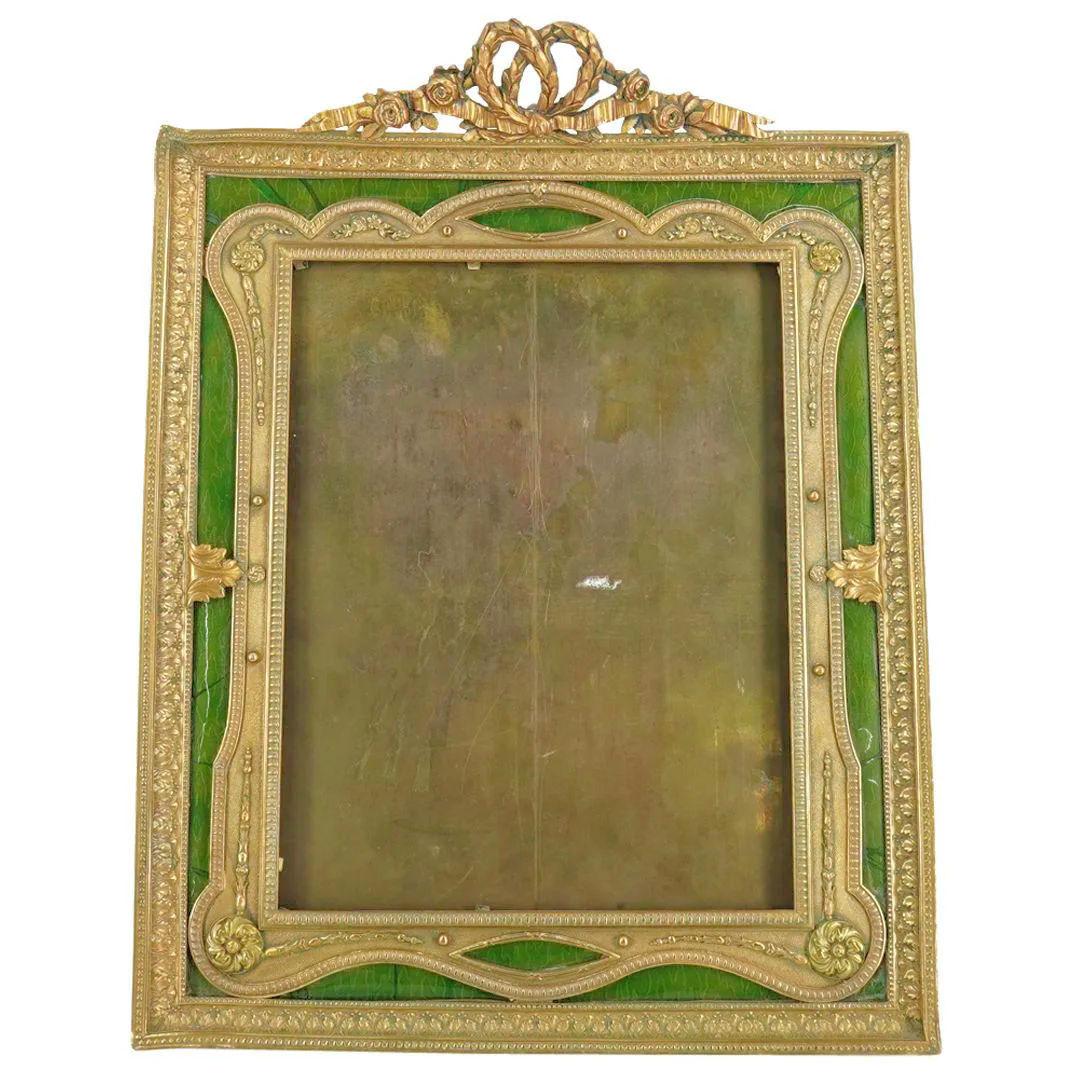 Our lovely gilt bronze picture frame in the Louis XVI style features emerald green enamel and fine neoclassical motifs including rosettes, ribbons and rose flower garlands. Rear stamped FRANCE mark.