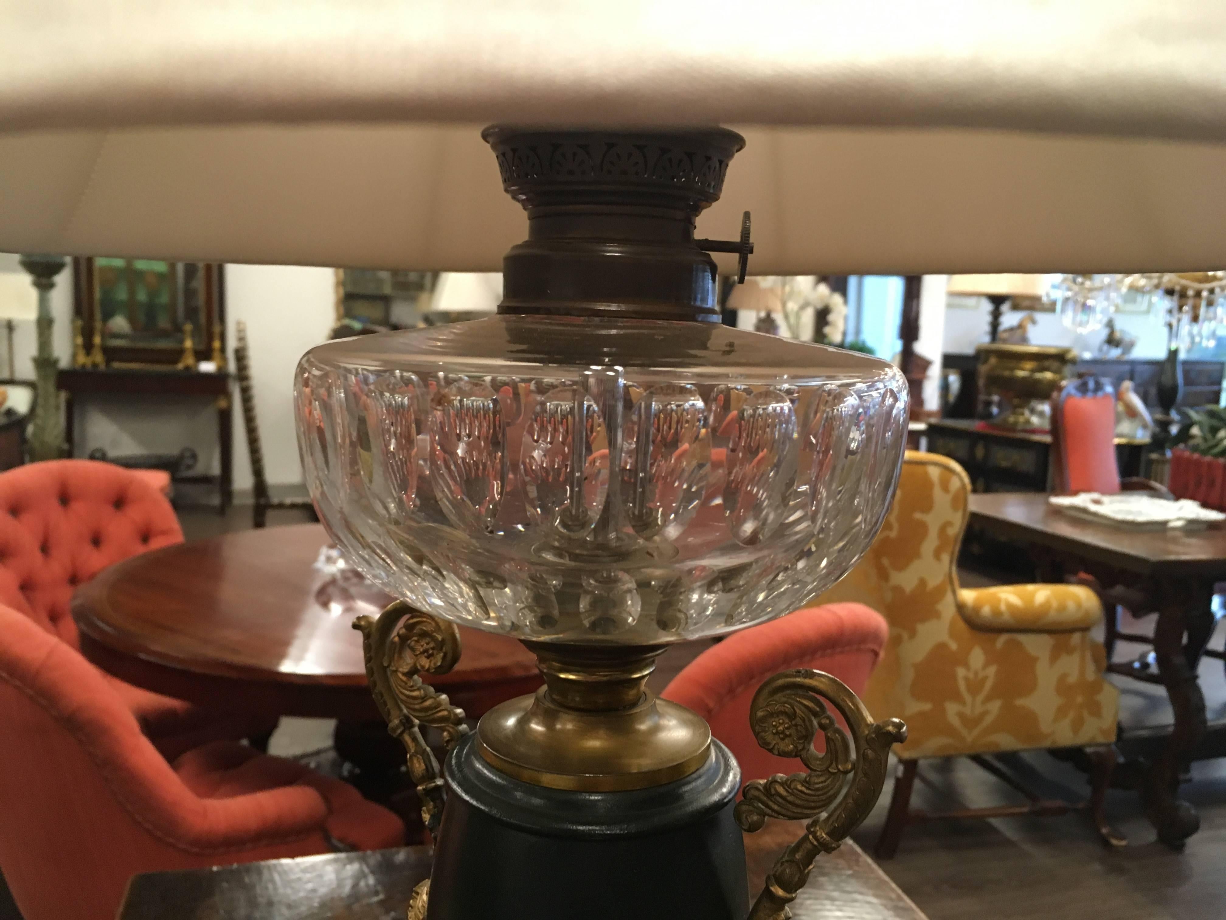 Impressive pair of characteristically neoclassical black and gold urn form table lamps on marble pedestals and topped with fluted crystal fonts. The gilt bronze decorative 