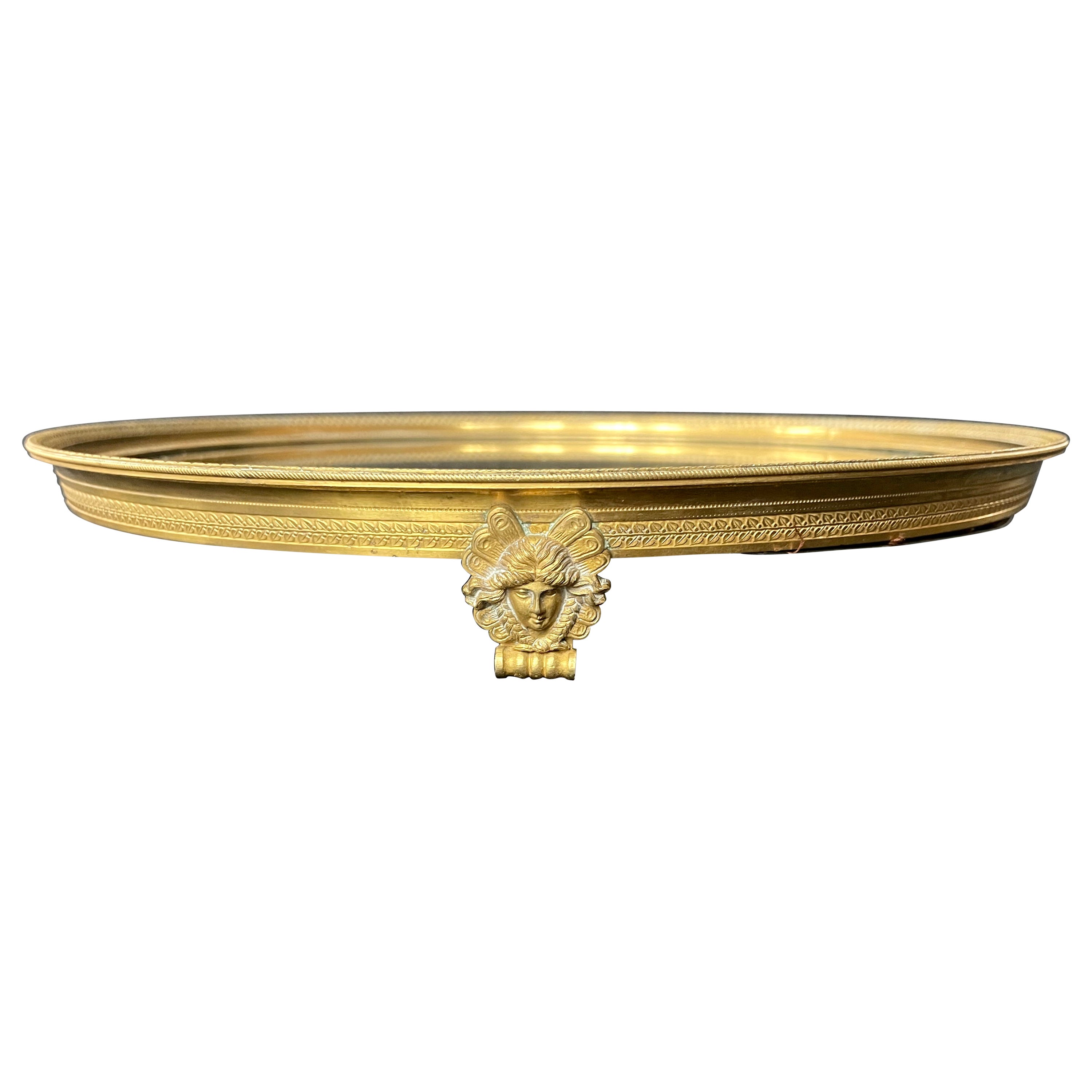 French neoclassical gilt Ormolu mirrored centerpiece. Gilt bronze circular framed sûrtout de table with original mirrored center framed by Emprire style border on raised neoclassical masked outscrolled feet. France late 19th century
Dimensions:
