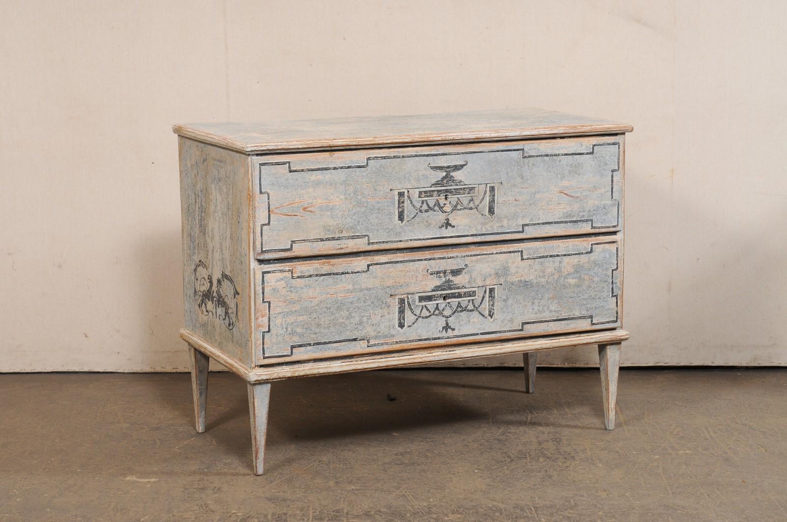 Cassapanca francese a due cassetti dipinta a mano del XIX secolo. Questa antica cassapanca francese è decorata con un motivo a urna e grifone dipinto a mano sulla parte anteriore e sui lati. Il piano di forma rettangolare si trova al di sopra di una