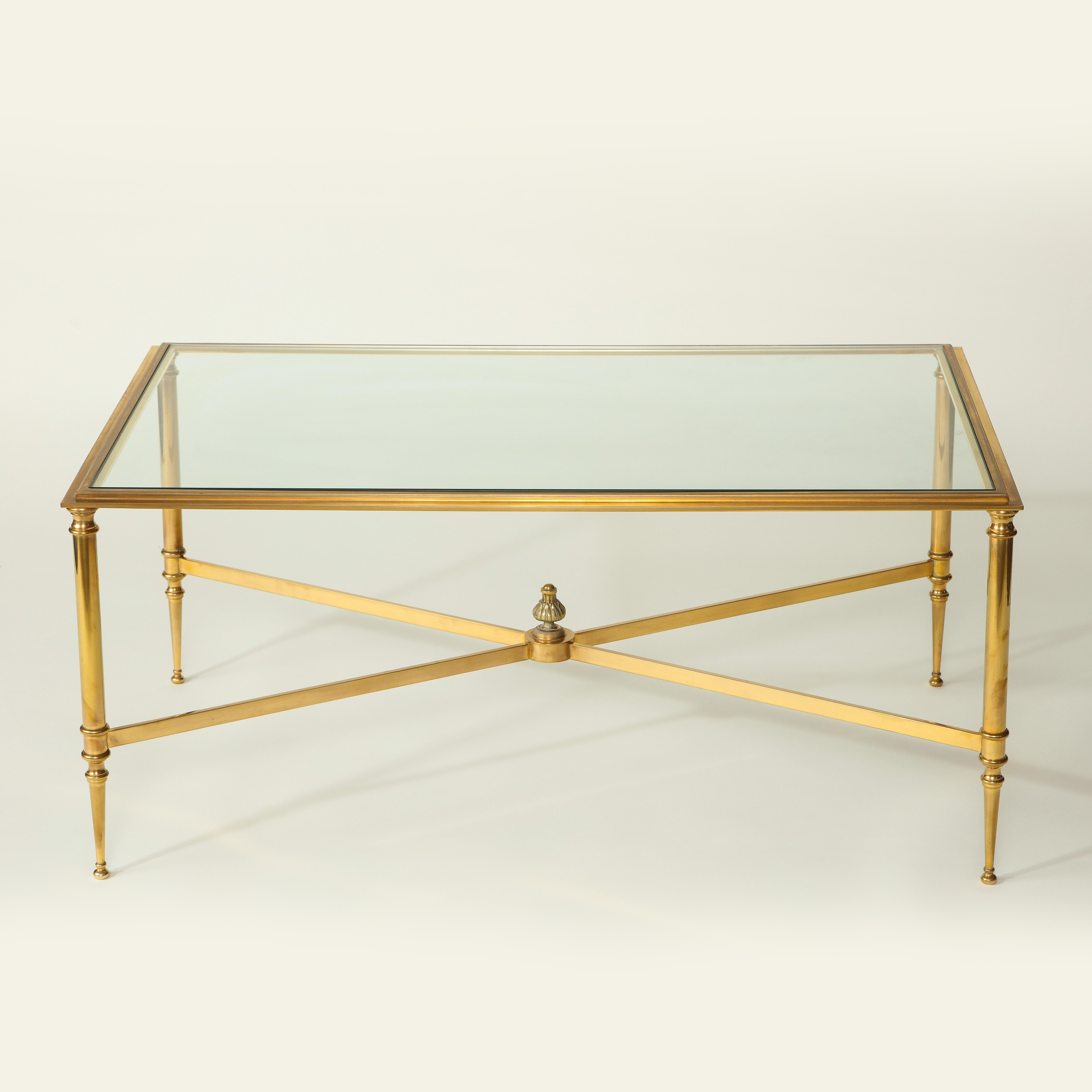 Possibly by Maison Baguès. The rectangular channeled top inset with clear glass raised on columnar supports terminating in tapering feet joined by an X-form stretcher surmounted by leaf-wrapped finial.