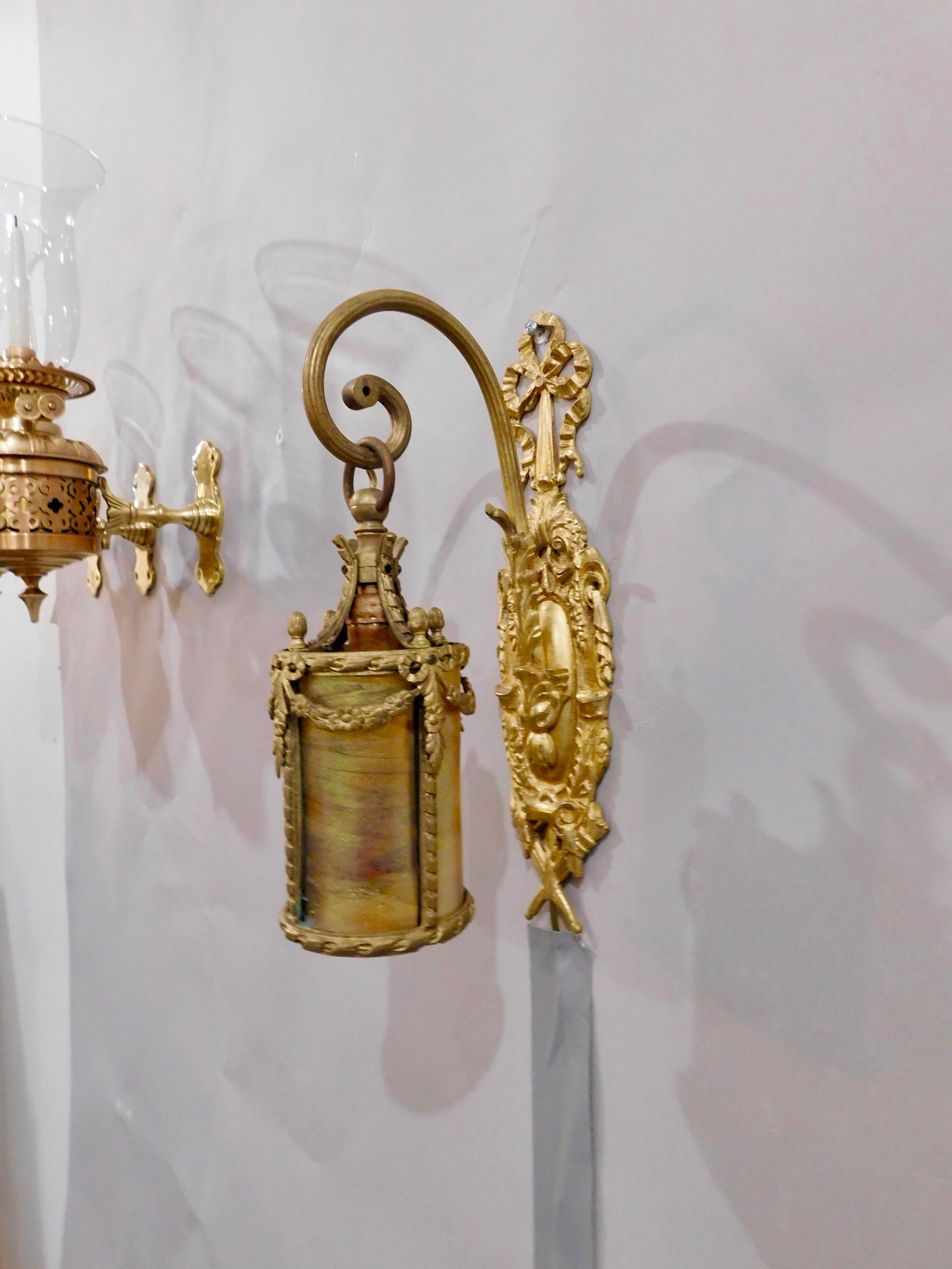 One-of-a-kind French Neoclassical Louis XVI style gilt bronze and brass sconce with Tiffany inspired tubular iridescent shade. Intricately detailed Neoclassical bow motif backplate, sprouting scrolled mount supporting Tiffany inspired tubular