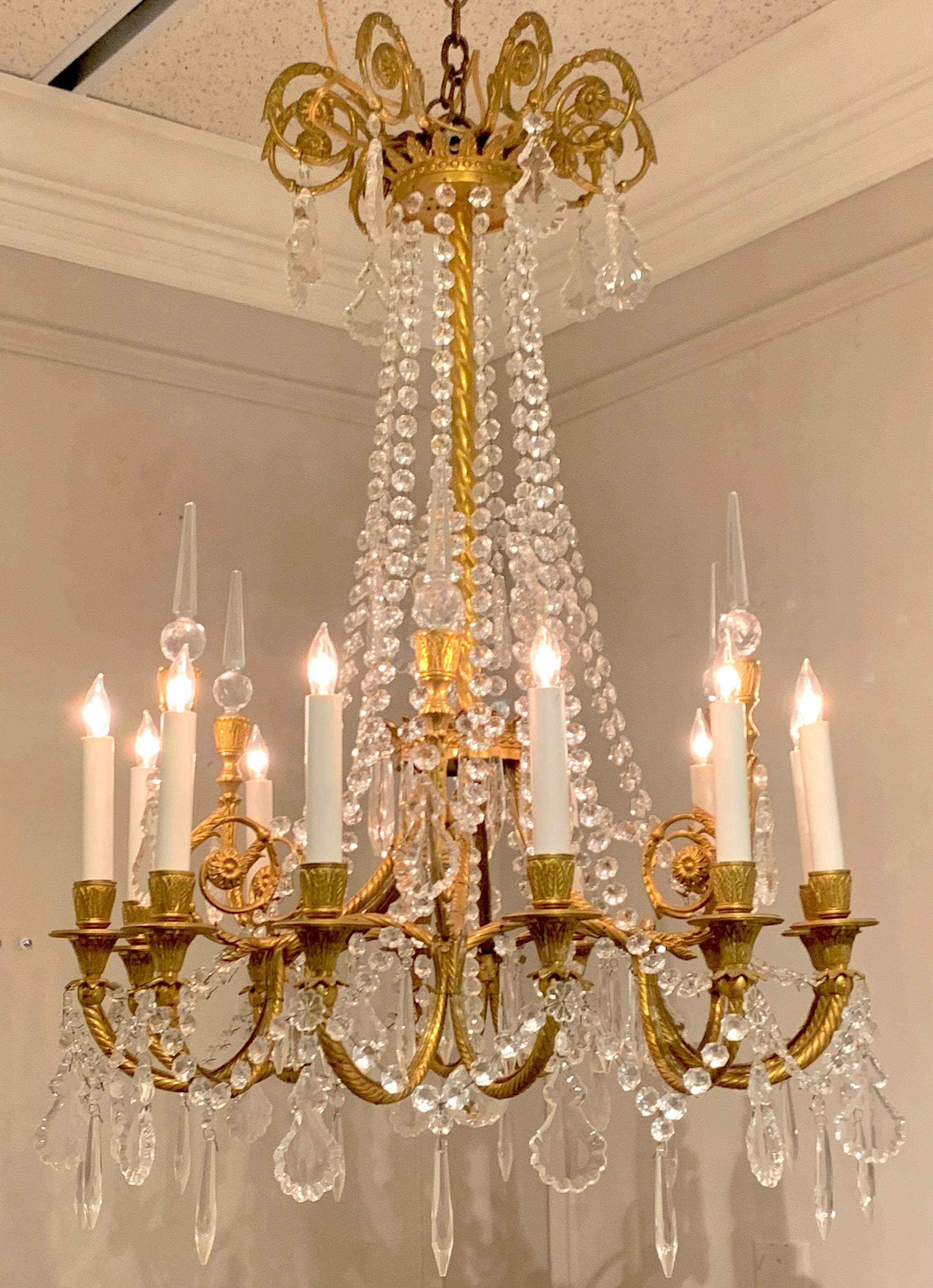 French neoclassical ormolu and crystal 12-light chandelier, Paris, circa 1910, in the style of Baccarat, with finely chased ormolu fittings, draped crystal center 'column' fitted with 12 lights and six crystal orb spears. Newly wired.