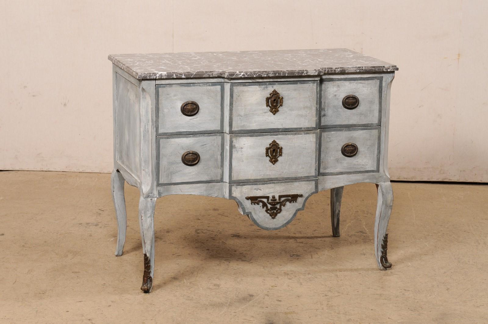A French Neoclassical carved and painted wood commode with marble top from the 19th century. This antique chest from France features a subtle break-front design that carries through from the marble top to the wood cabinet below. The charcoal top