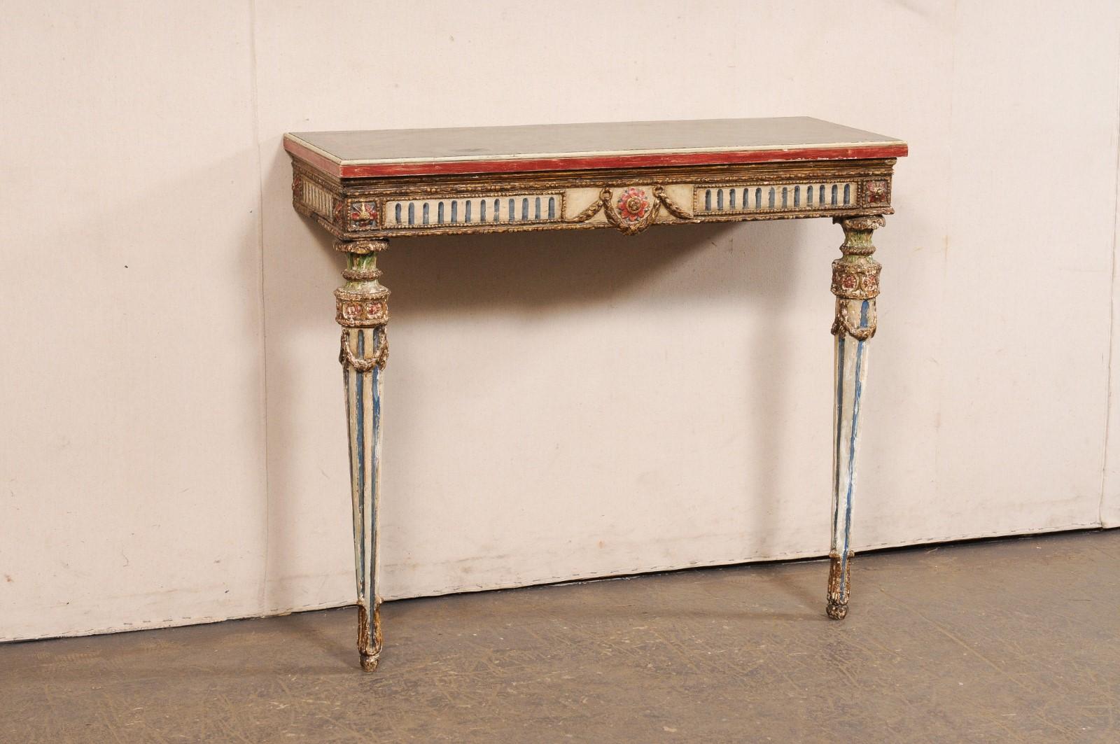 A French period Neoclassical carved and painted wood wall mounted console table from the turn of the 18th and 19th century. This antique table from France has a slender, faux-marble painted and rectangular-shaped top, over a fluted apron adorn with