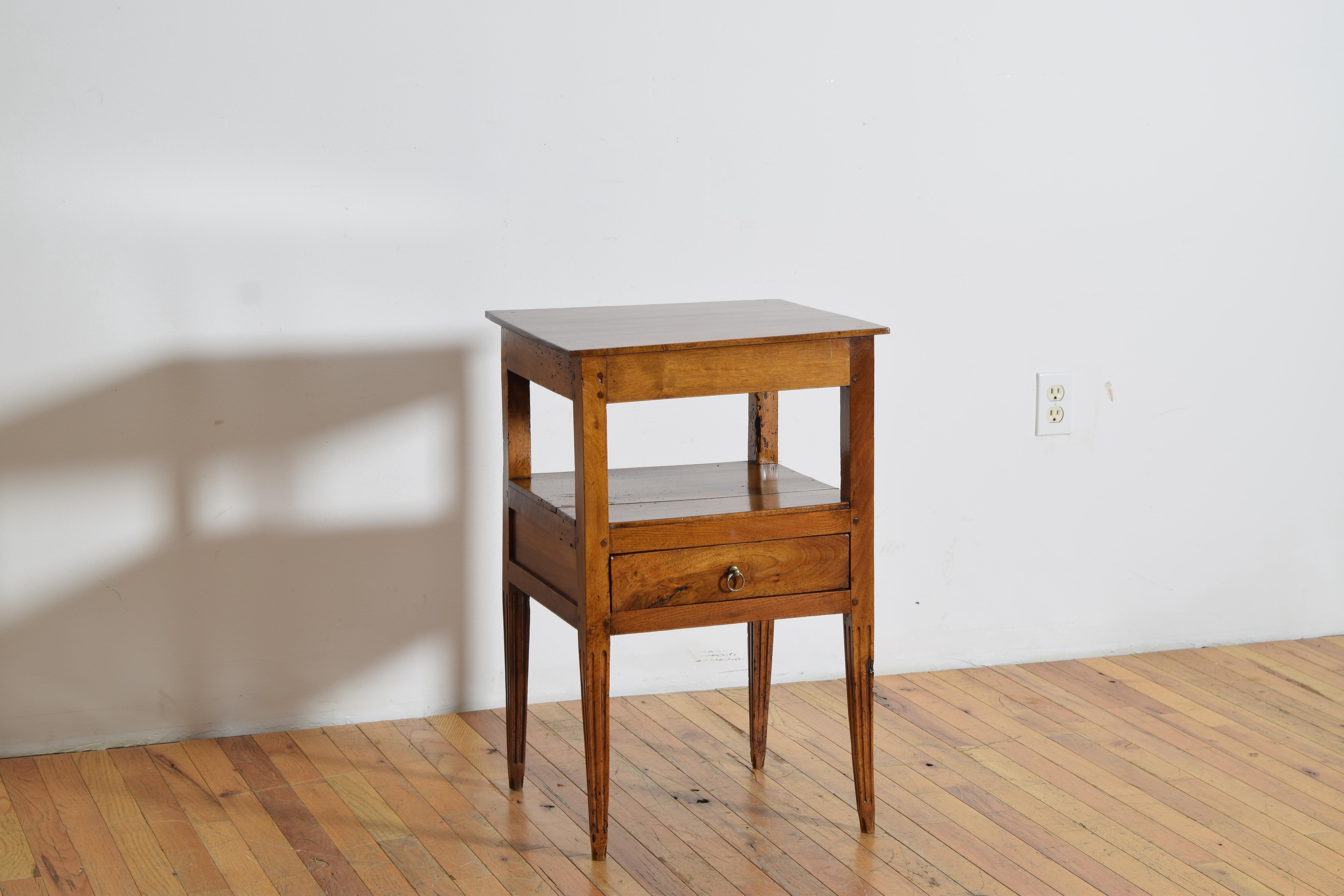Table d'appoint française en noyer massif datant du milieu ou de la fin du XIXe siècle, comportant un seul tiroir, une étagère ouverte au milieu et des pieds inférieurs cannelés et fuselés.