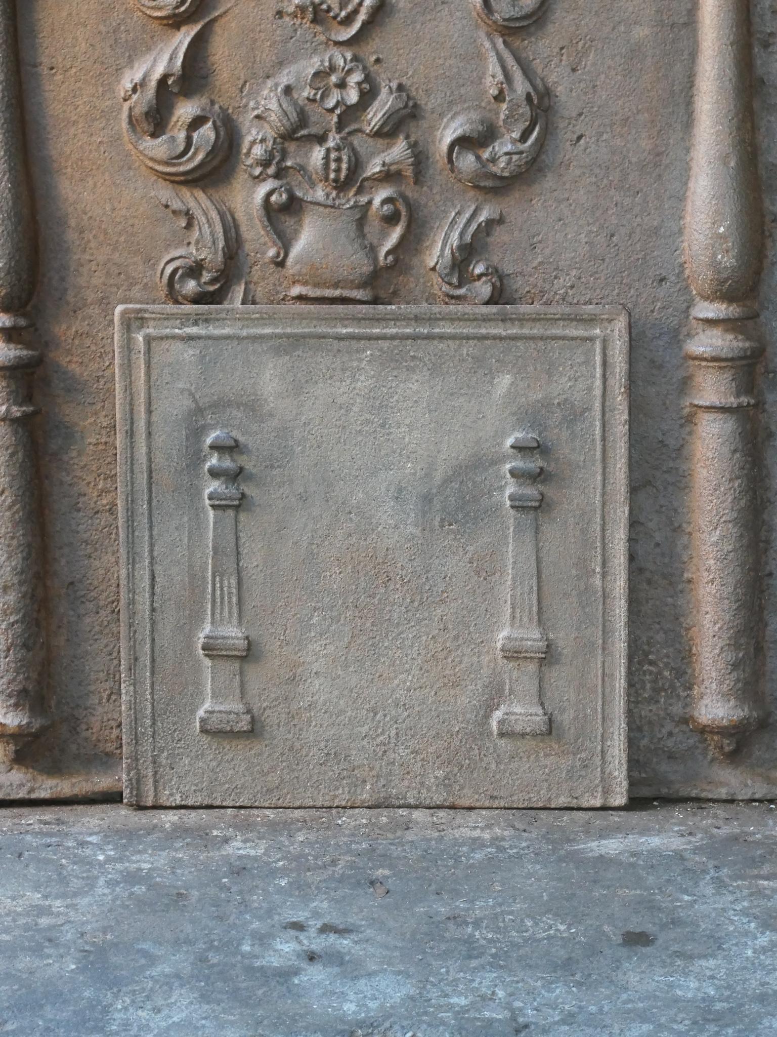 18th - 19th Century French neoclassical fireback with two pillars of freedom. The pillars symbolize the value liberty, one of the three values of the French revolution. 

The fireback is made of cast iron and has a brown patina. Upon request it