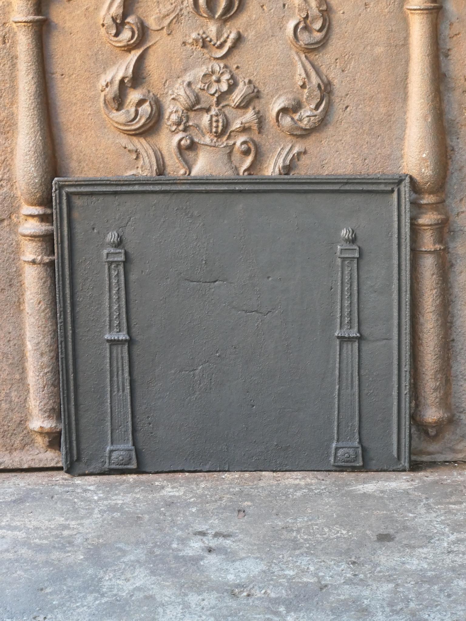 18th - 19th Century French neoclassical fireback with two pillars of freedom. The pillars symbolize the value liberty, one of the three values of the French revolution. 

The fireback is made of cast iron and has a black / pewter patina. It is in