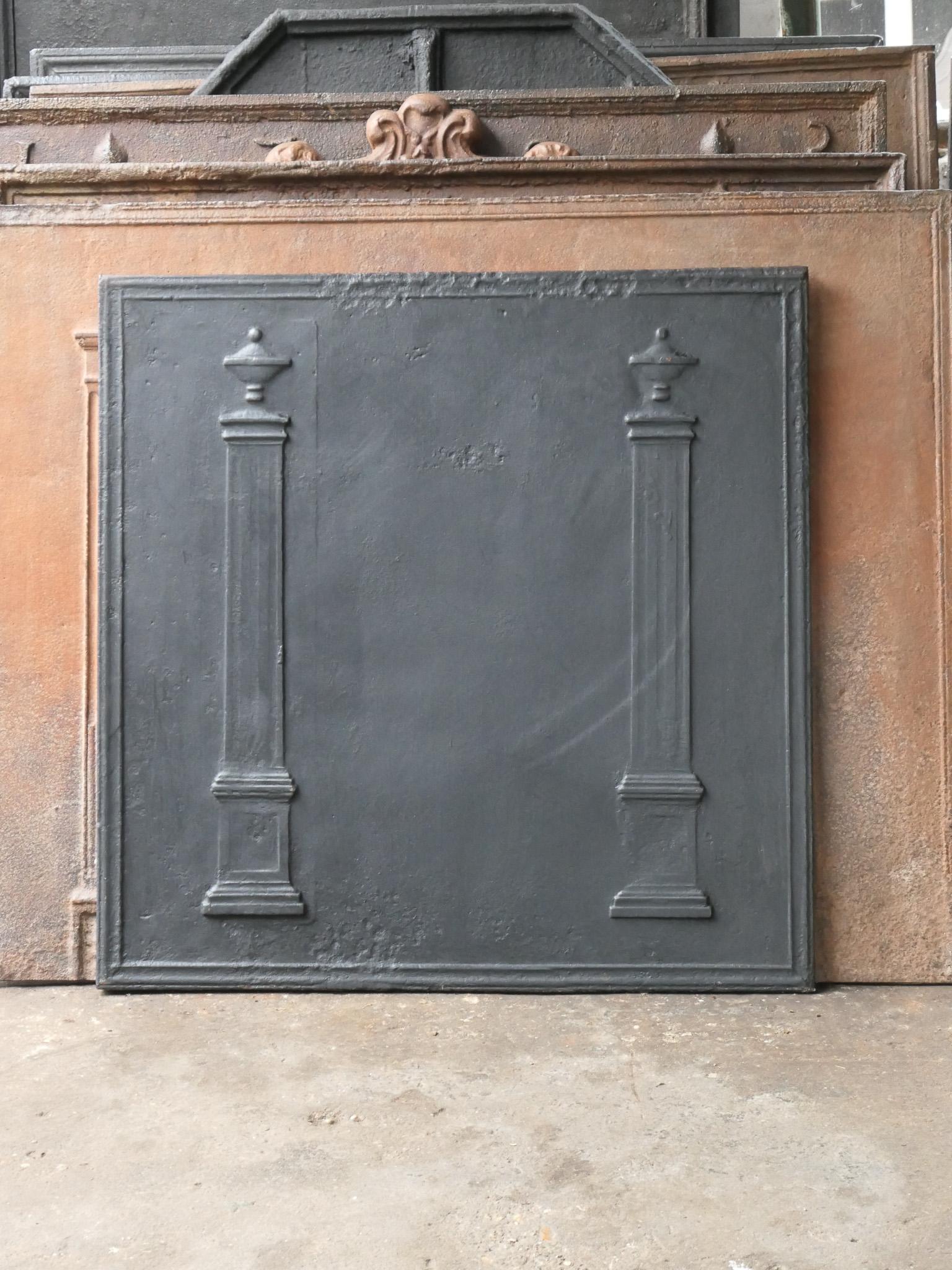 18th - 19th Century French Neoclassical fireback with two pillars of freedom. The pillars symbolize the value liberty, one of the three values of the French revolution. 

The fireback is made of cast iron and has a black / pewter patina. It is in a