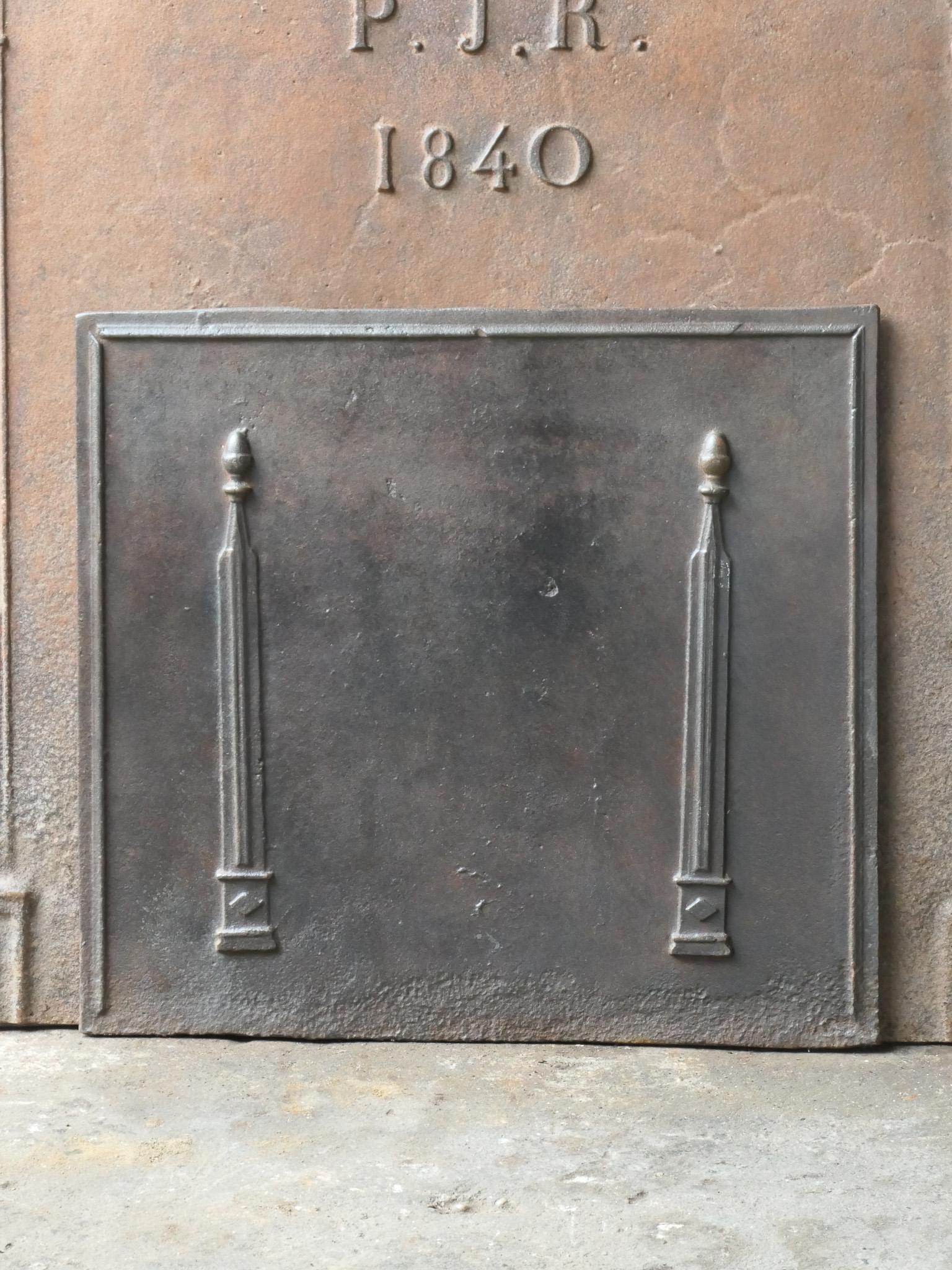 19th century French neoclassical fireback with two pillars of freedom. The pillars symbolize the value liberty, one of the three values of the French revolution. 

The fireback is made of cast iron and has a natural brown patina. Upon request it