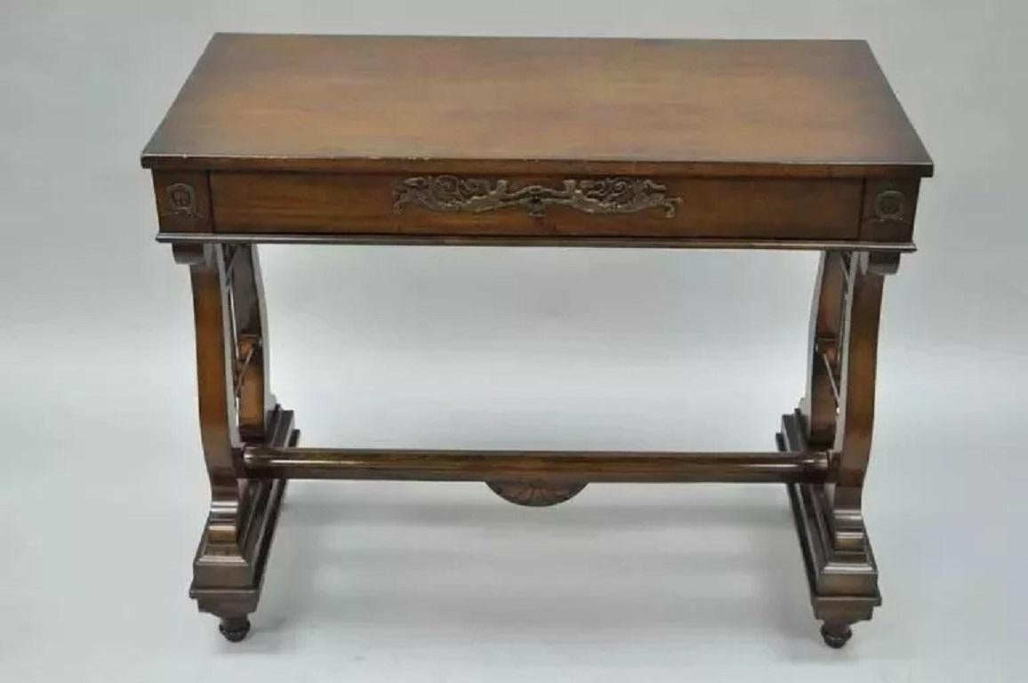 Antique French Neoclassical Regency Style Mahogany One-Drawer Lyre Desk Console Table. Item features a mahogany wood frame, carved lyre form legs, stretcher base, single dovetail constructed center drawer, brass figurative ormolu, finished back,