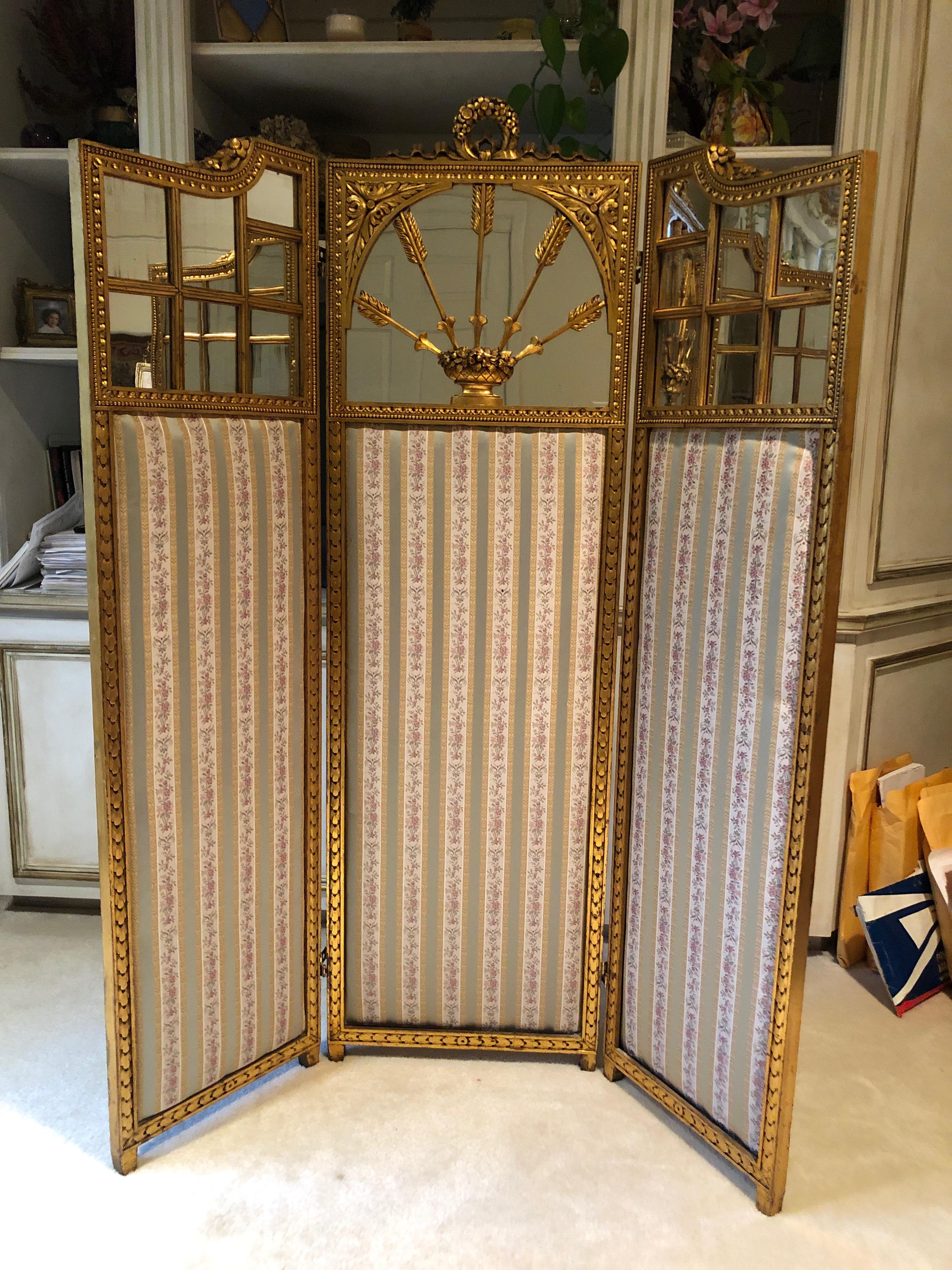 A sublimely elegant versatile antique French neoclassical folding screen having central panel with cresting of a garland with crimped ribbon ties over a square mirrored panel edged in running bead and acanthus banding, acanthus leaf spandrels and