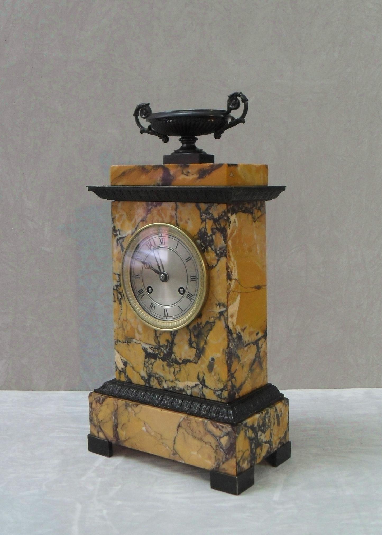 An extremely good quality French neoclassical sienna marble mantel clock with bronze acanthus leaf moldings and urn to the top stood on bronze feet with decorative brass bezel. The clock has a silvered dial with a French eight day movement which