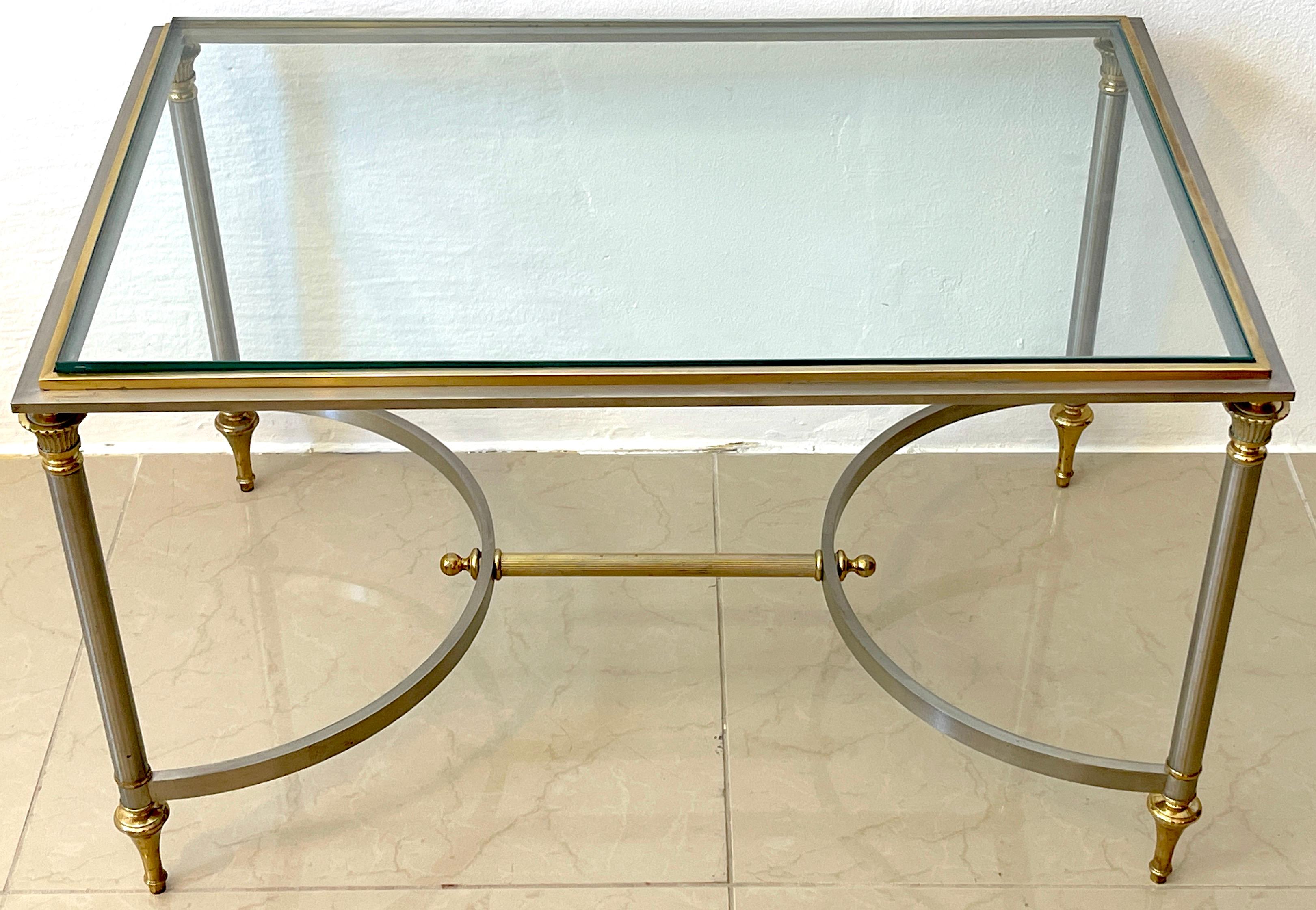 French neoclassical steel & gilt bronze coffee table, style of Maison Jansen, Of rectangular form with inset thick glass top, raised on four column legs joined by center stretcher.