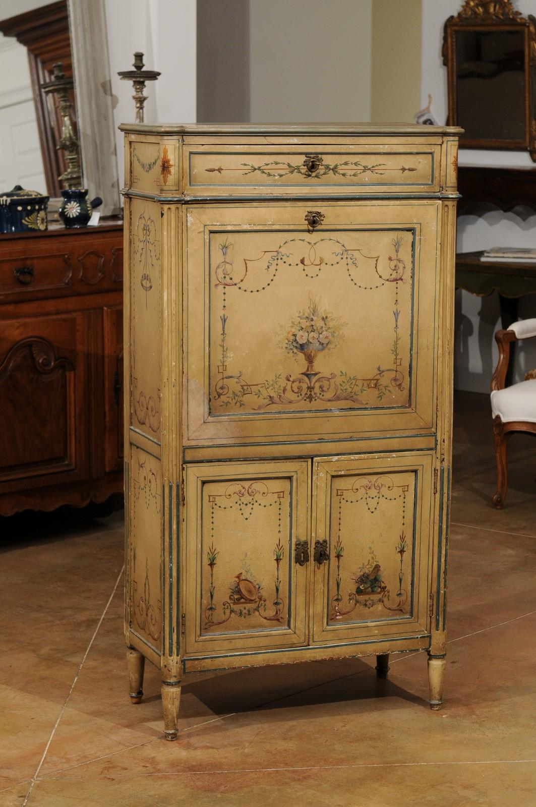 A French Neoclassical style painted secretary from the 19th century, with flowers, arabesques, musical instruments and birds. Created in France during the 19th century, this painted secrétaire features a narrow drawer at the top sitting above a drop