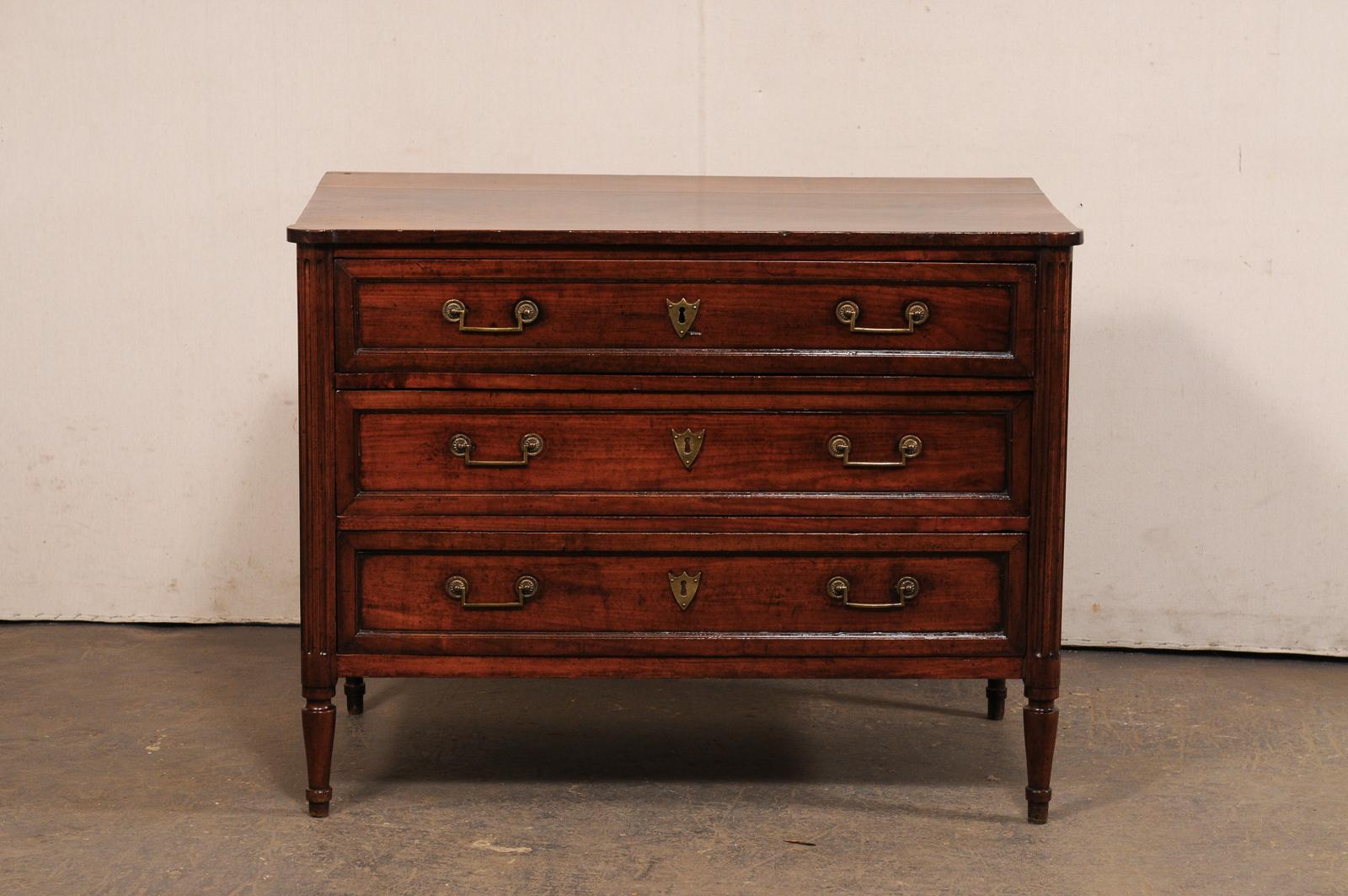 Cassettiera in legno intagliato in stile neoclassico francese del XIX secolo. Questa cassapanca antica proveniente dalla Francia ha un piano di forma rettangolare, con angoli anteriori arrotondati ed enfatizzati, che sovrasta leggermente la cassa