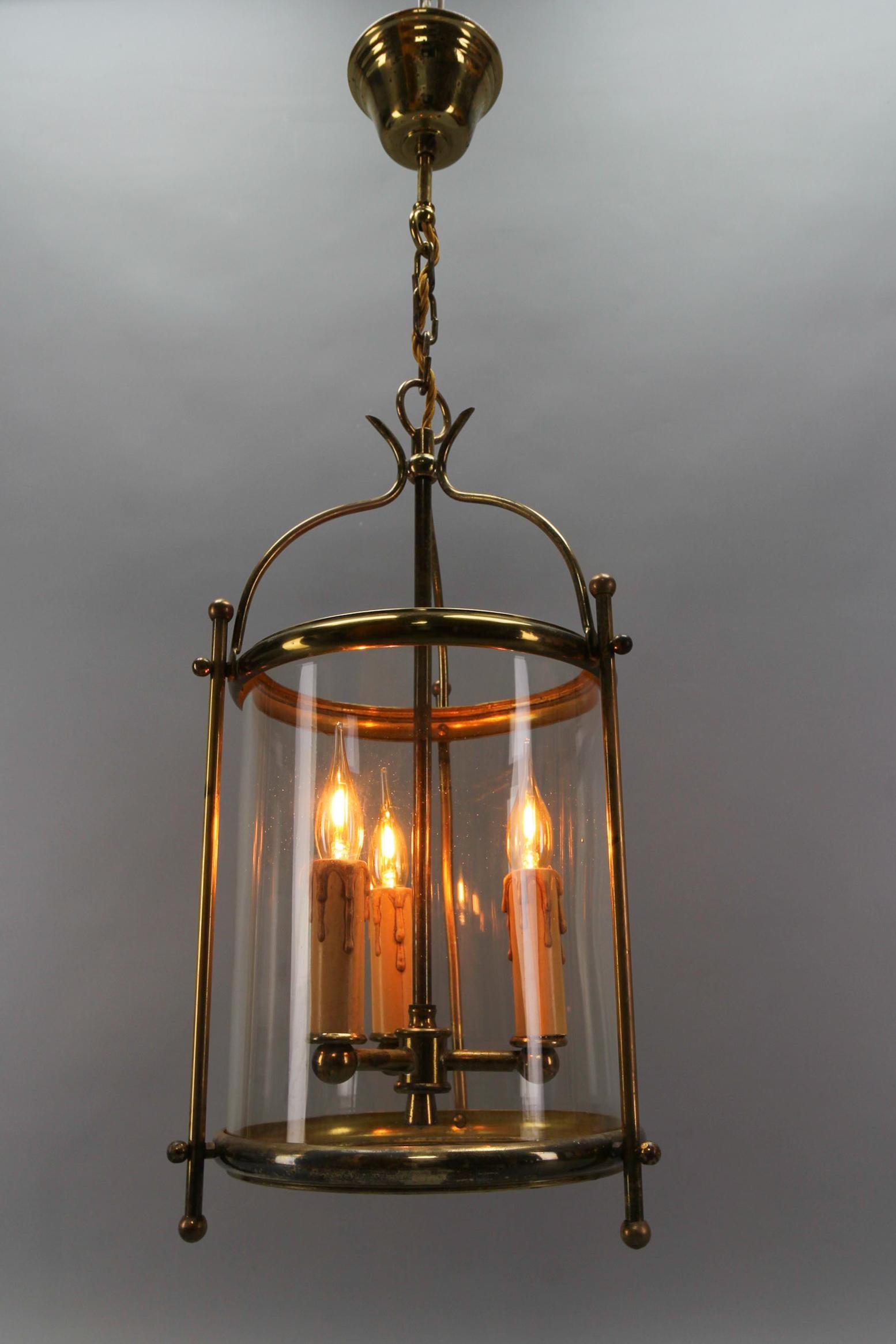 Lanterna a sospensione a tre luci in ottone e vetro trasparente francese risalente agli anni '50 circa.
Questa adorabile lanterna a sospensione a tre luci presenta un'elegante struttura rotonda in ottone con un paralume rotondo in vetro