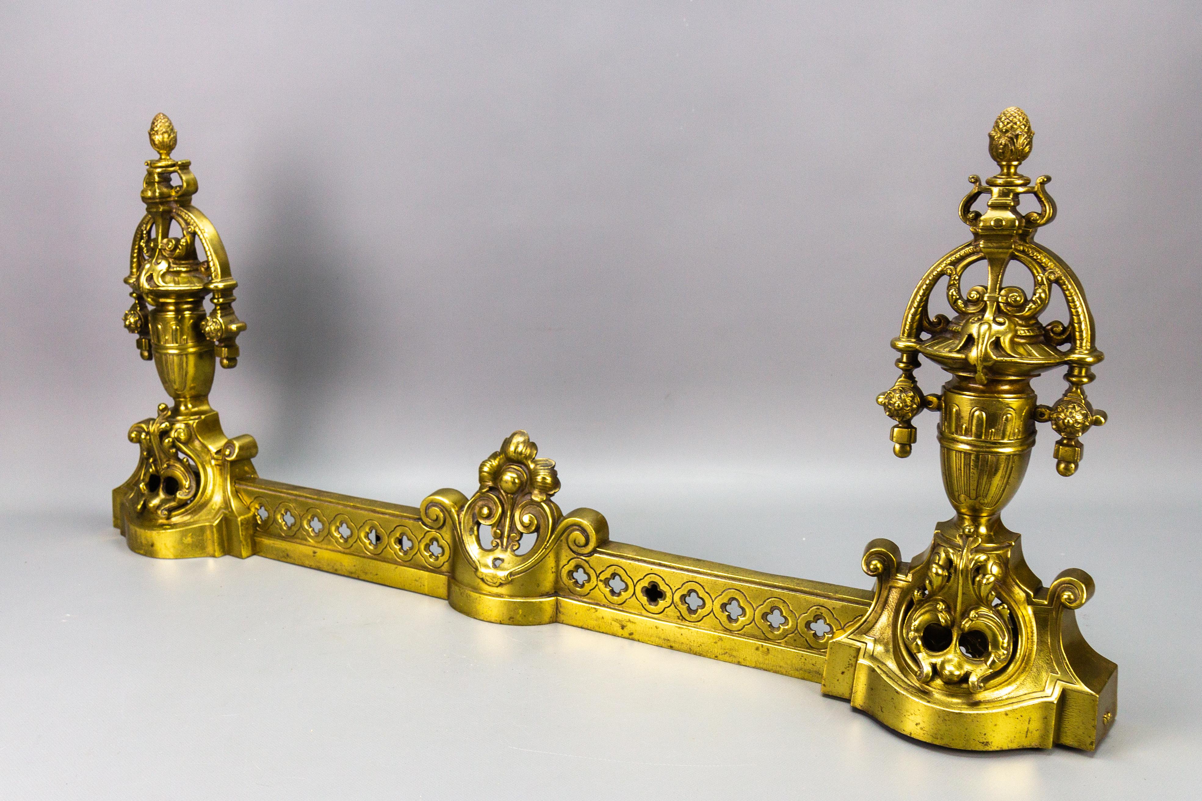 French Neoclassical style bronze fireplace fender set from circa 1920, sold as a set of 3.
This impressive French Neoclassical style bronze fender set is richly ornate with foliate accents, urns, and acorn finials.
In good antique condition, with