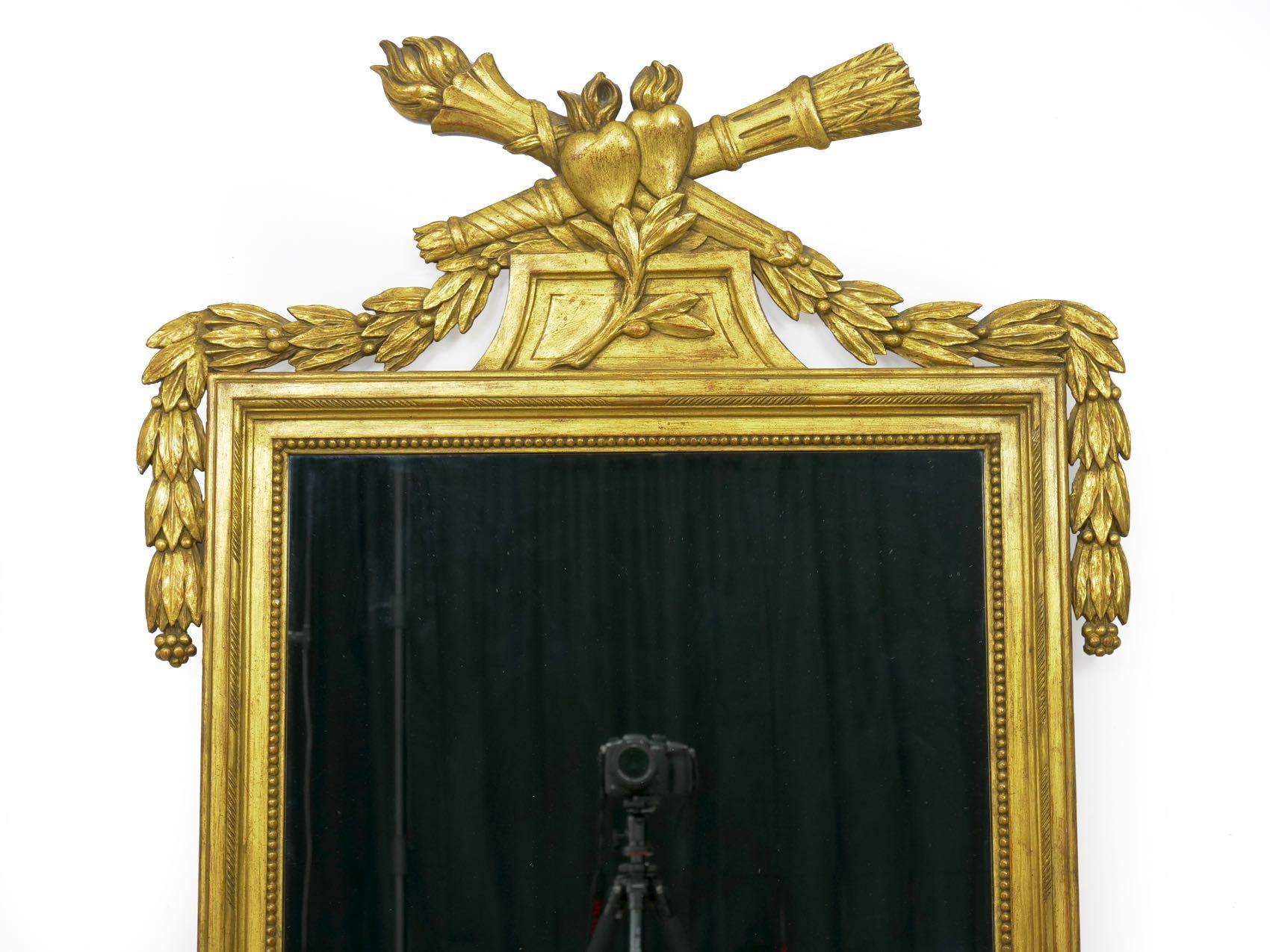 A fine handmade vintage giltwood mirror in the French neoclassical taste, it is likely a product of the first half of the 20th century and shows fine craftsmanship throughout. There is a distinct modernity about the form, a departure from the highly