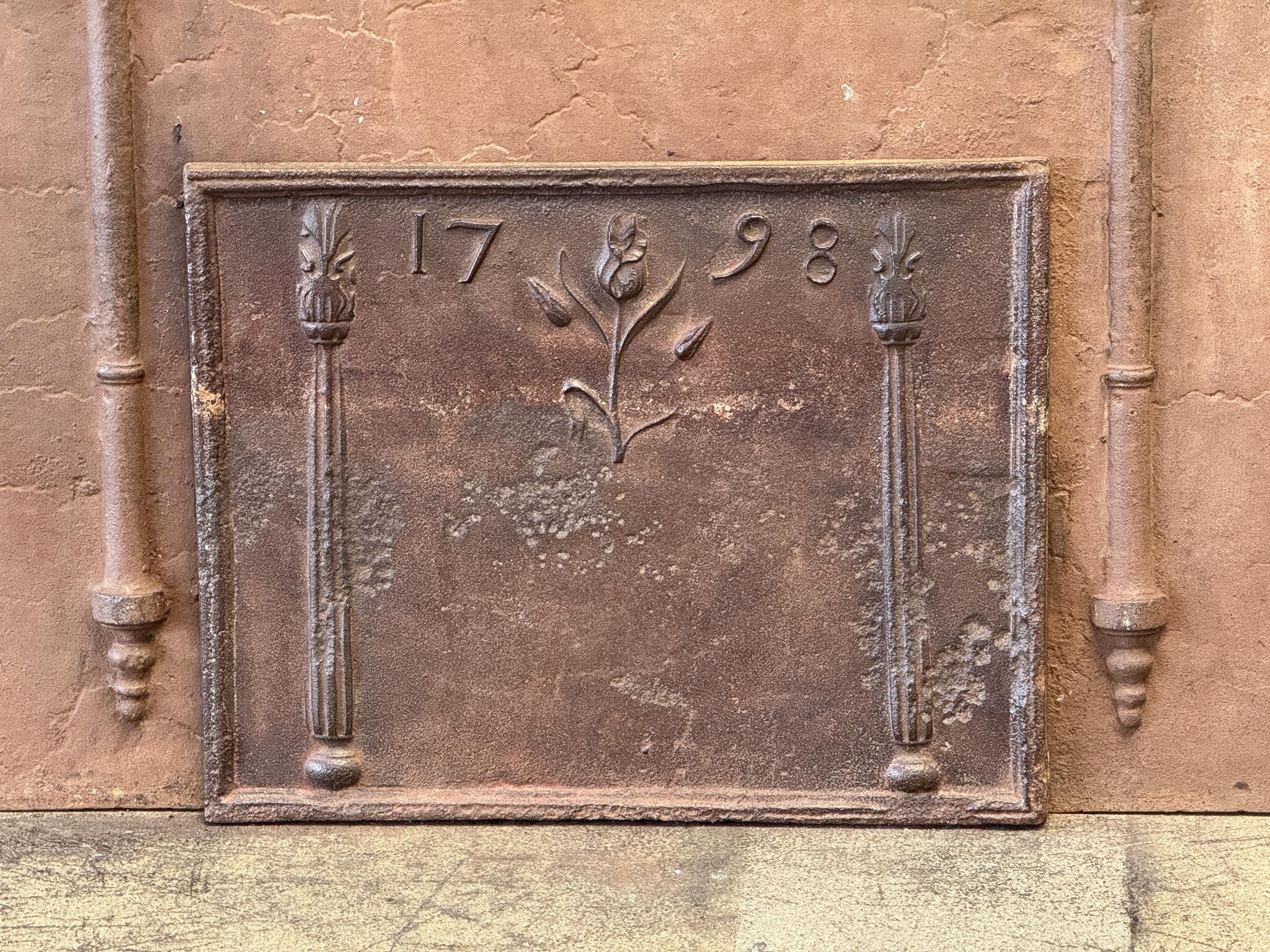 French Neoclassical Period Fireback / Backsplash, 18th Century depicting decorated pillars and a tulip.

The fireback is made of cast iron and has a natural brown patina. Upon request, it can be made black / pewter. The fireback is in good condition