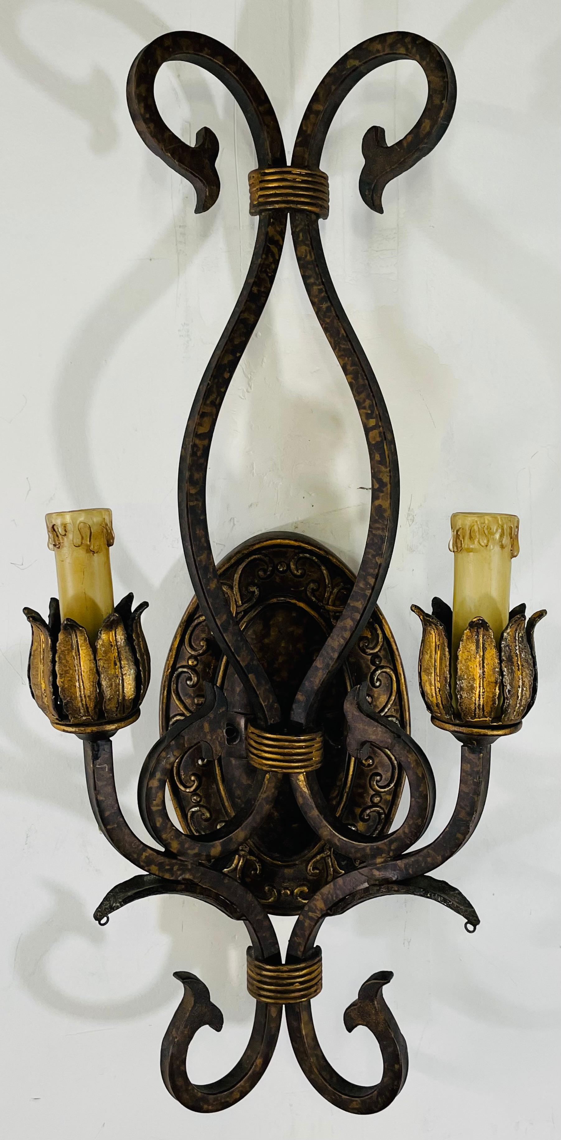 An elegant pair of French Neoclassical style sconces. The two-arm metal sconces are finely gild decorated and painted in a tortoise shell color tone adding a fashionable and stylish touch to the timeless Traditional Design of the scones. Each sconce