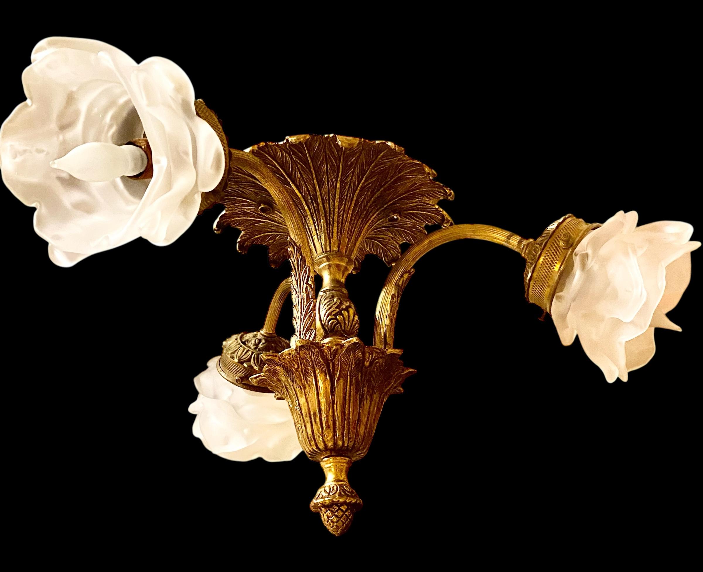 Antique French Neoclassical style bronze, brass, and frosted glass ceiling fixture, circa 1920. Questa adorabile lampada da soffitto a tre luci in stile neoclassico presenta un baldacchino imponente e ornato, tre bracci con un paralume in vetro a
