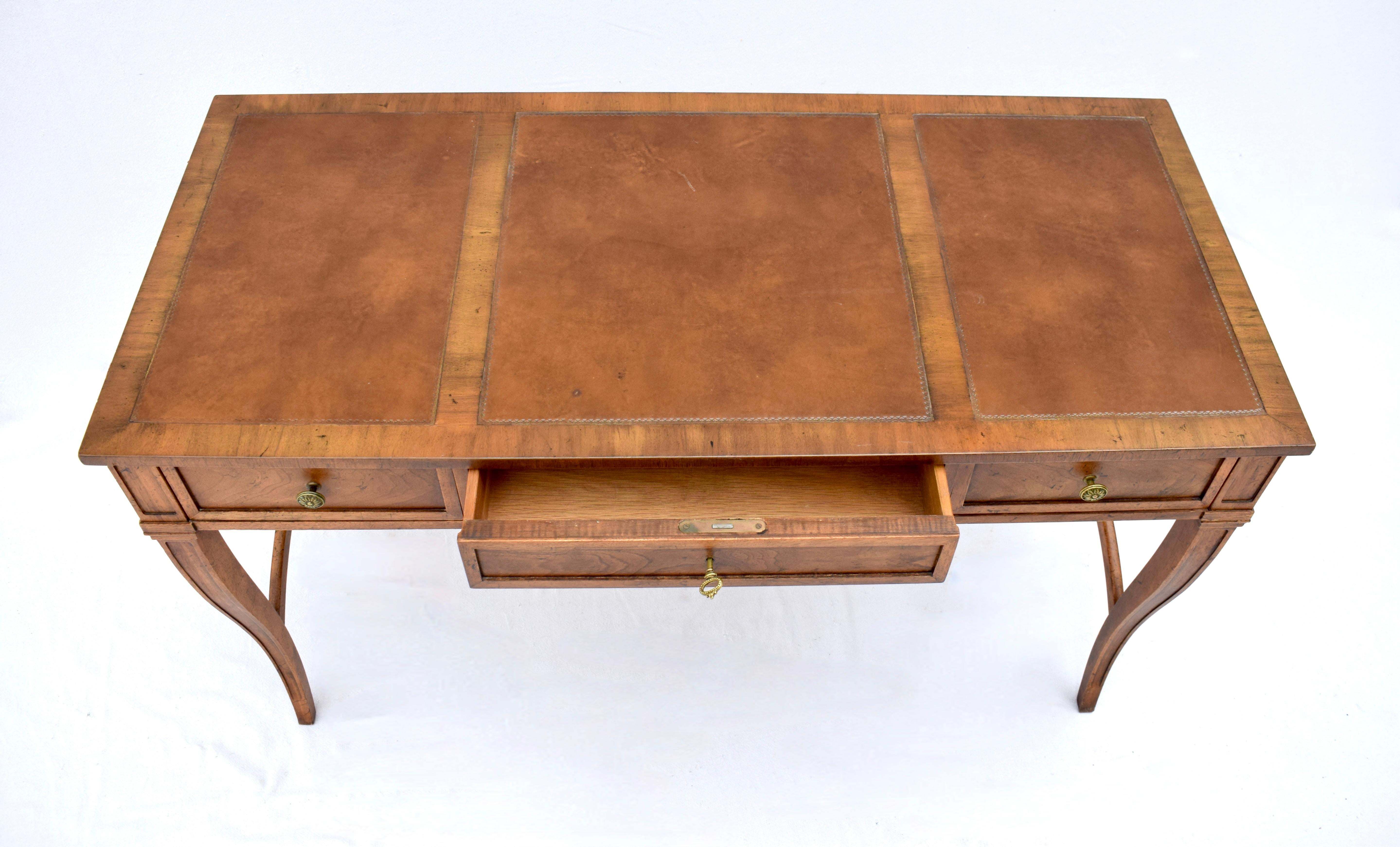 Squisita scrivania Baker Furniture con piano in pelle a fasce, tre cassetti a coda di rondine e serratura e chiave funzionanti. Eleganza e semplicità con una patina calda e lustrale nella finitura originale strofinata a mano.