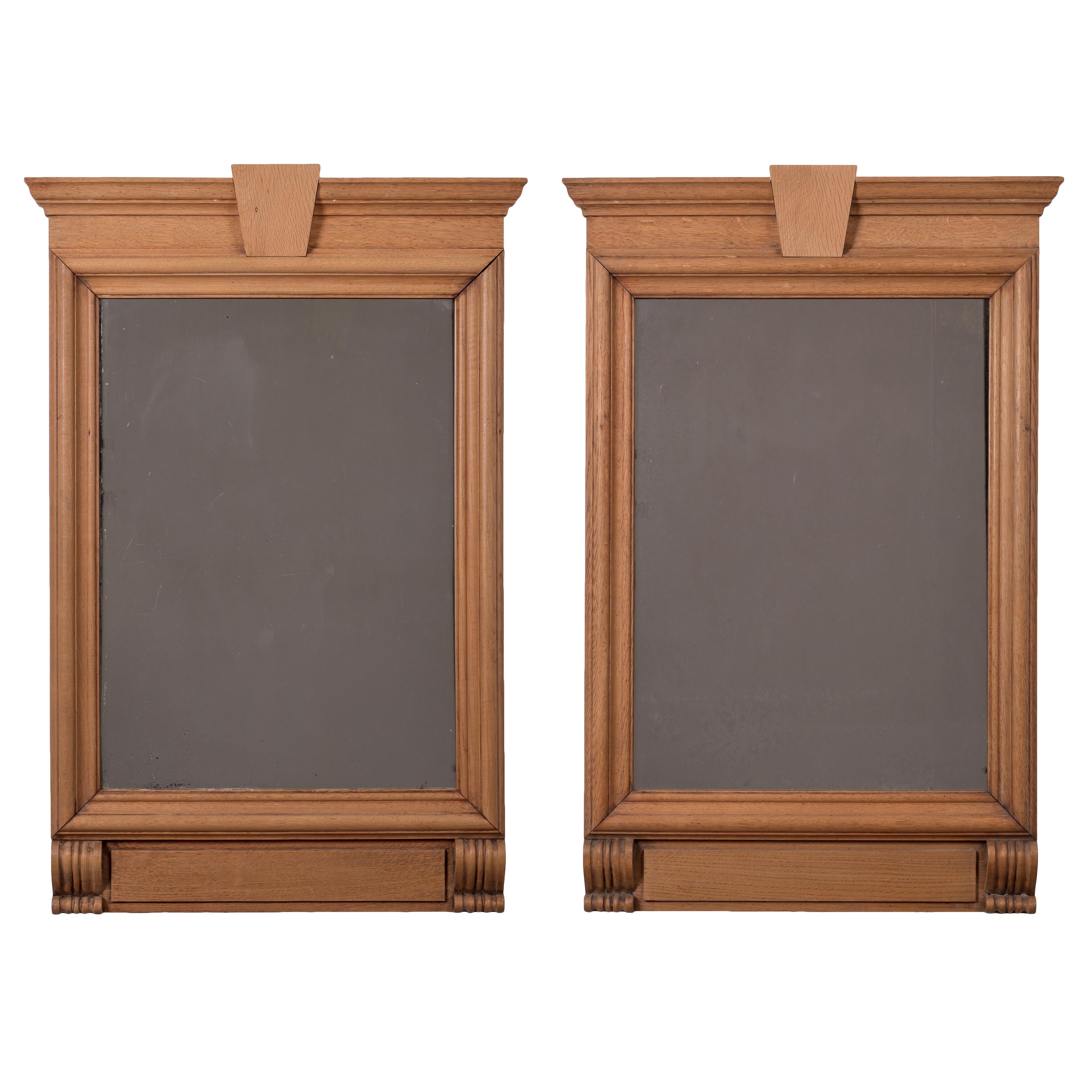 A pair of French neoclassical style limed oak trumeau mirrors, 19th century.
Antique plates; molded cornice above linear frames supported by two carved brackets.

28 ¾ inches wide by 43 inches tall by 2 ¼ inches deep