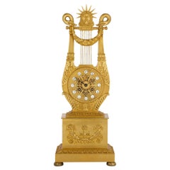 Reloj de bronce dorado con forma de lira de estilo neoclásico francés