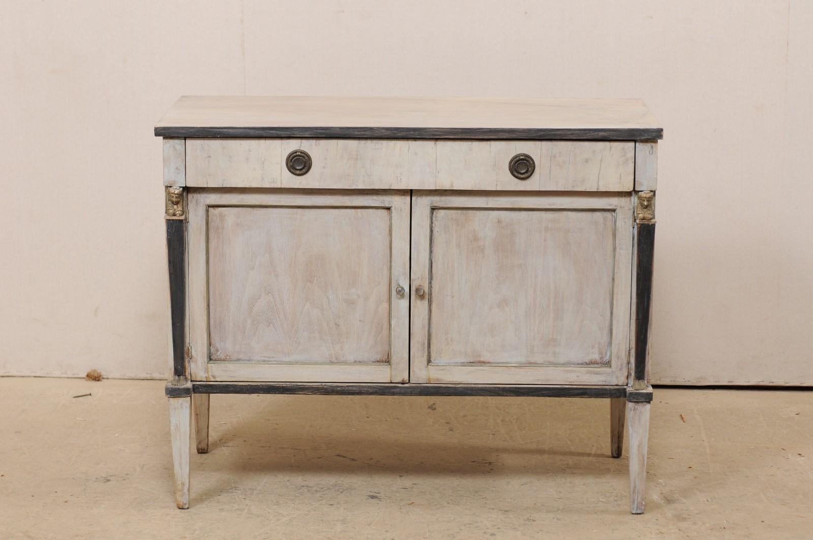 A French neoclassical style smaller-sized, raised buffet cabinet from the early 20th century. This antique cabinet from France features a rectangular-shaped top above a case designed with clean lines and column-style side posts flanking the doors