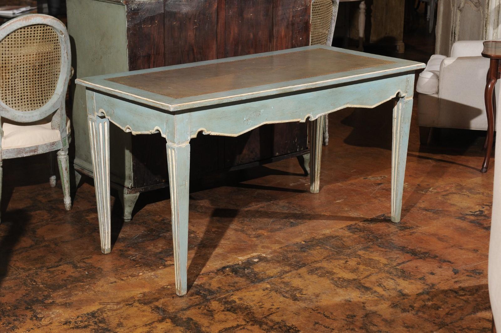 A French Neoclassical style painted wood desk from the 20th century, with tooled leather top, tapered legs and single drawer. Born in France during the 20th century, this elegant painted wooden writing table features a rectangular top with inset