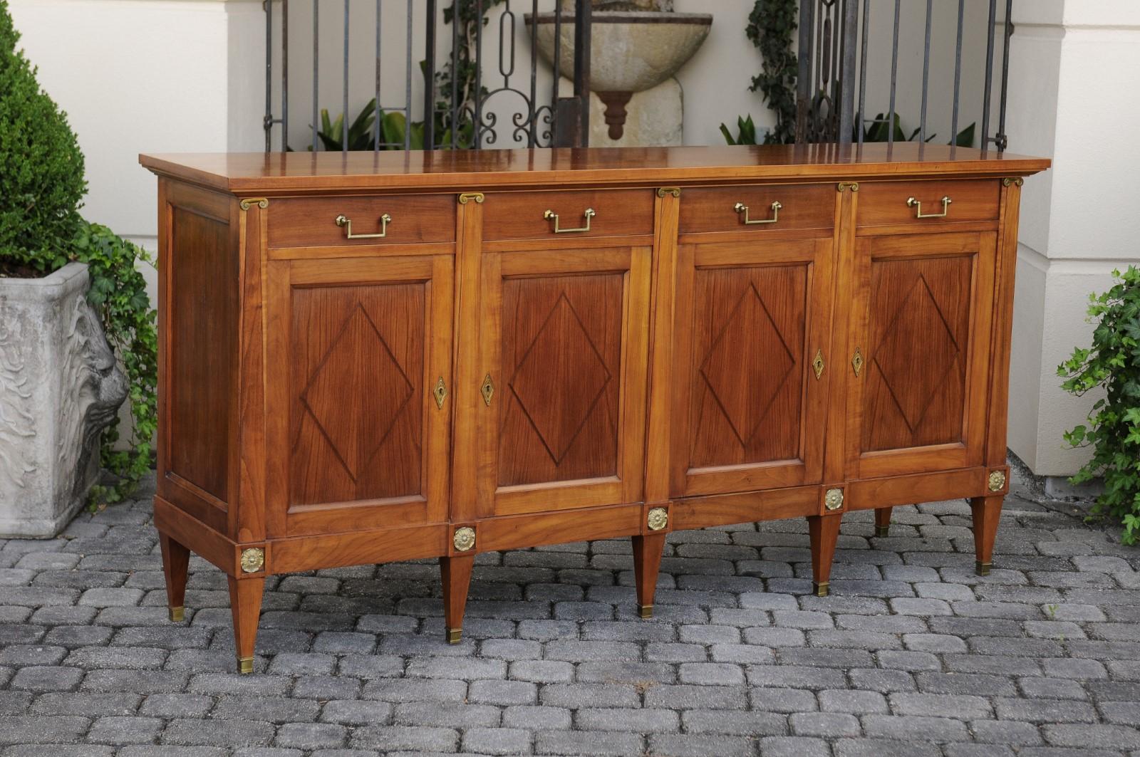 A French vintage neoclassical style walnut enfilade from the mid-20th century, with Ionic pilasters, diamond motifs, four drawers over four doors. Born in France during the midcentury period, this exquisite walnut enfilade features a rectangular top