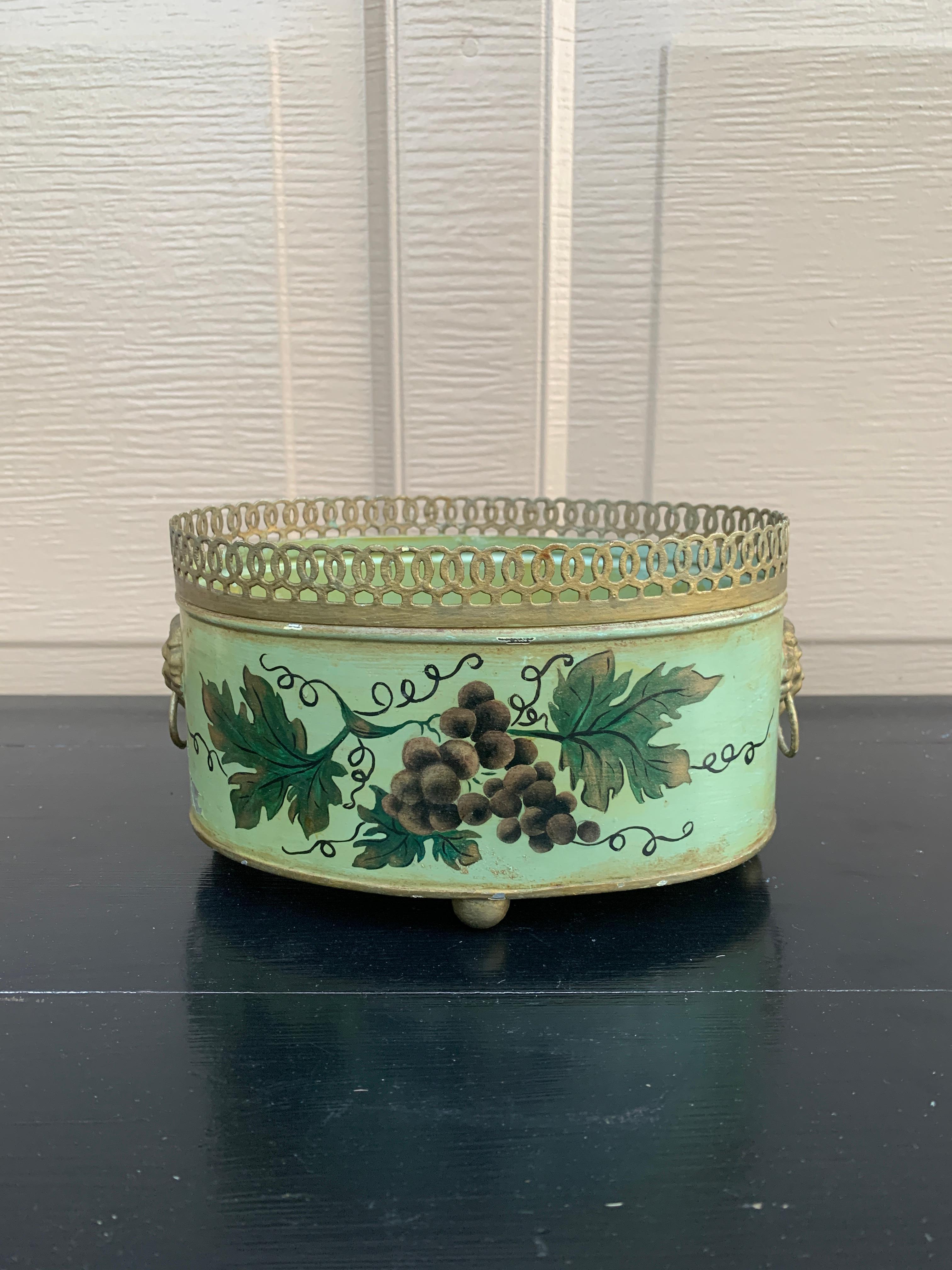 Precioso cacharro, maceta o jarrón neoclásico de tole verde y dorado con vides pintadas a mano y asas doradas con cabeza de león

Francia, alrededor de mediados del siglo XX

Medidas: 8