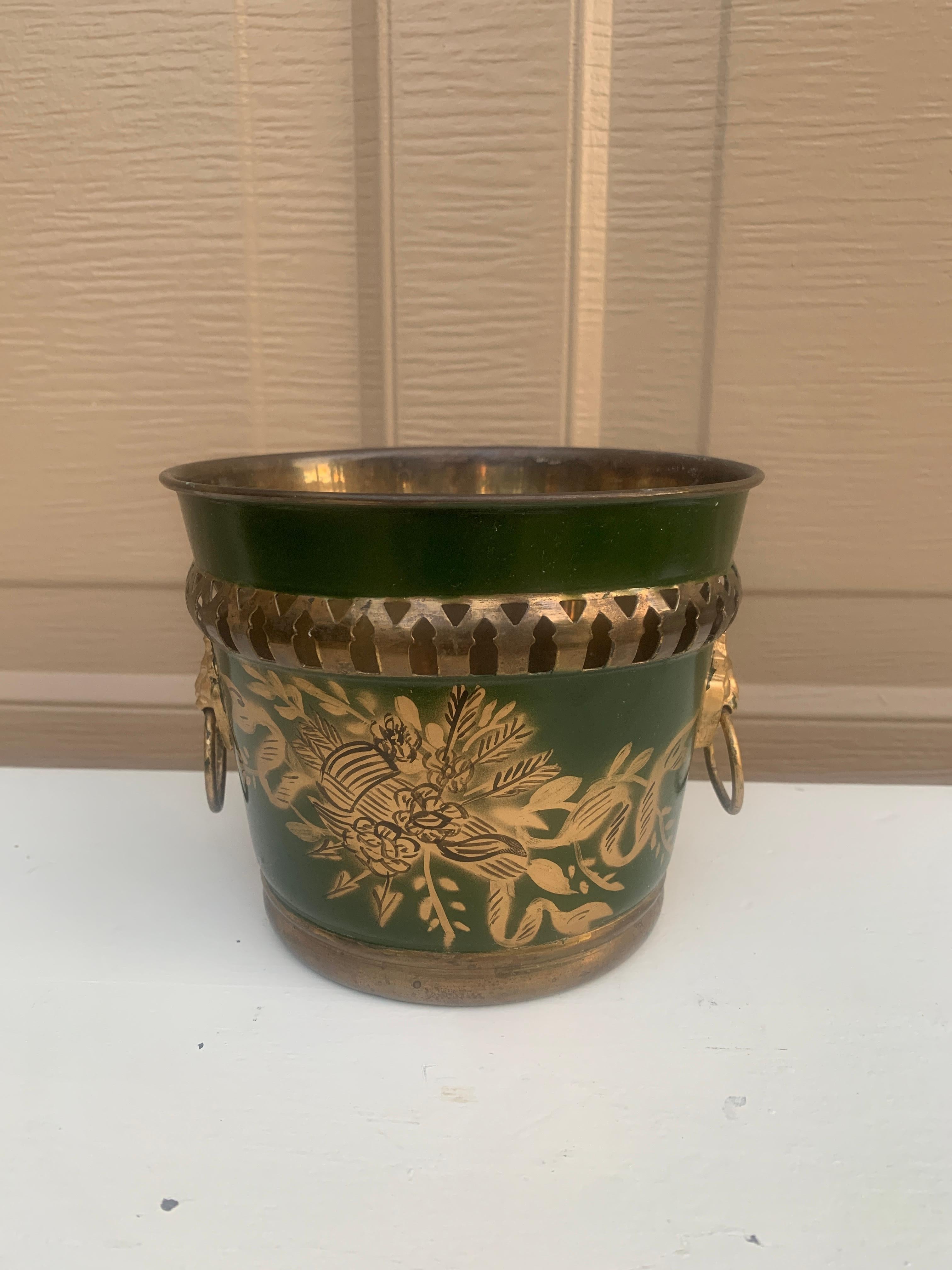 A gorgeous neoclassical green & gold tole cachepot, planter, or vase with head-painted details and brass lion heads

France, Circa Early 20th Century

Measures: 6