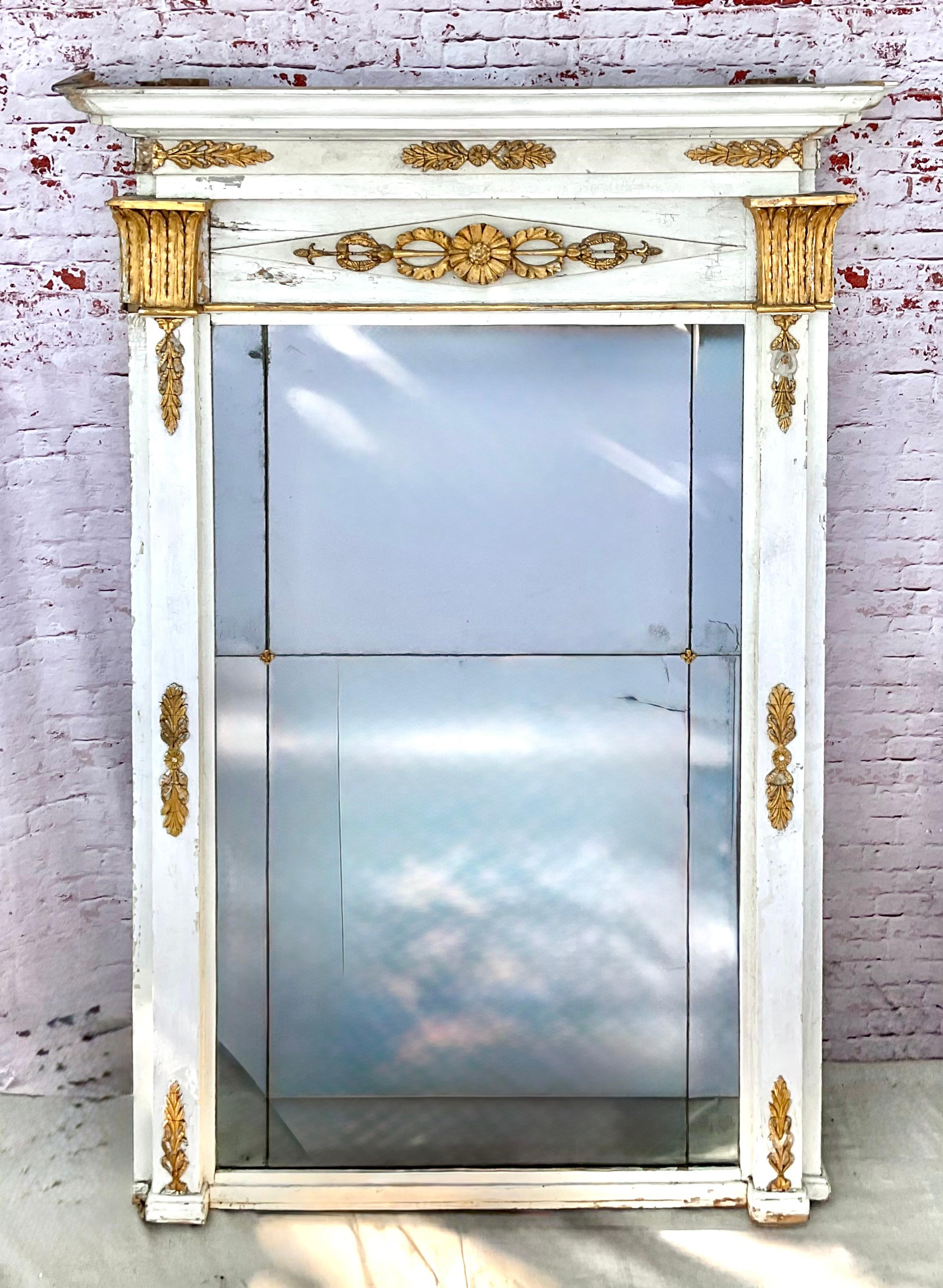 Specchiere neoclassiche francesi a molo dipinte di bianco e dorate a pacco.
Rara coppia di specchi neoclassici di grande formato dell'inizio del XIX secolo in legno dorato e dipinto. Le cornici intagliate sono dipinte di bianco con dettagli floreali
