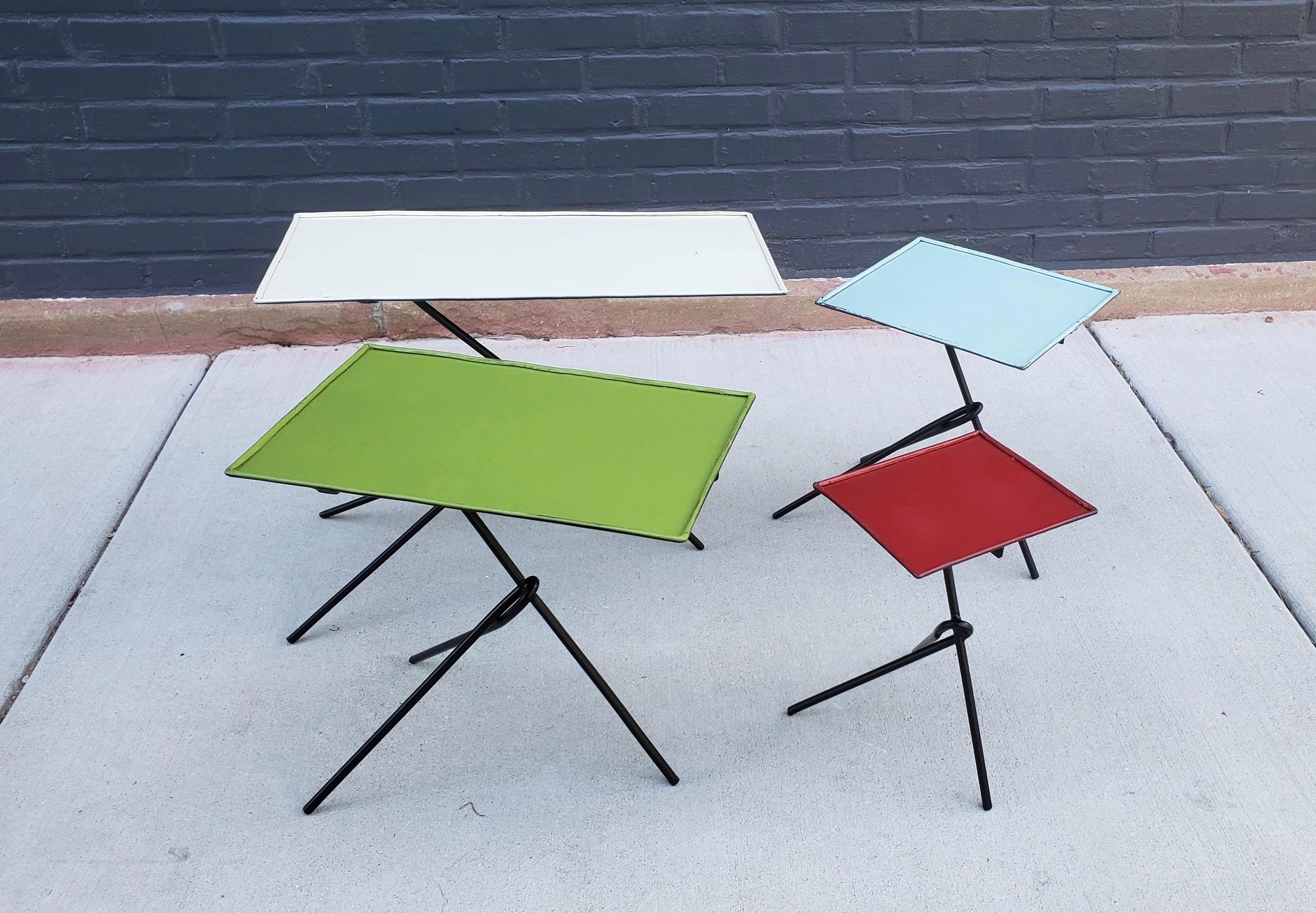 Unique set of French iron legged and enamel topped tables in the style of Matégot in ivory, green, blue, and red can be arranged in a multitude of configurations.