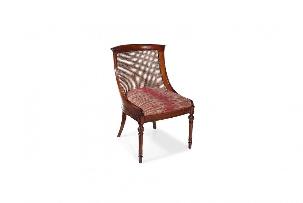 A stunning French Neuchâtel dining chair, 20th century.

Shown in cherrywood with an antique black finish and details in gold leaf, the Neuchâtel dining chair is entirely carved by hand. It features an incredible curved seat back and beautiful