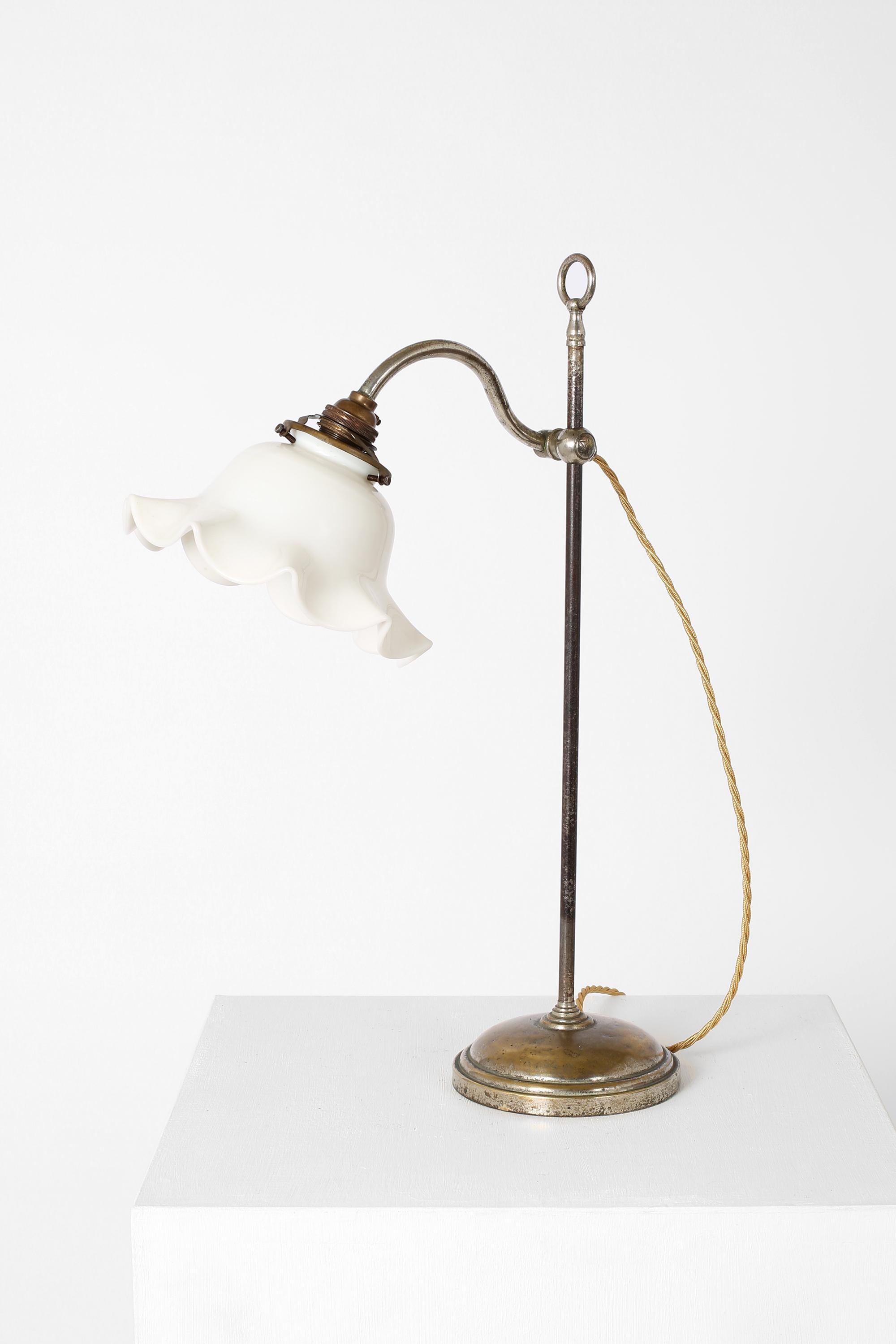 A nickel plated steel and bronze Art Nouveau desk/table lamp, with ruffled milk glass shade on a counterweight arm. French, c. 1900.